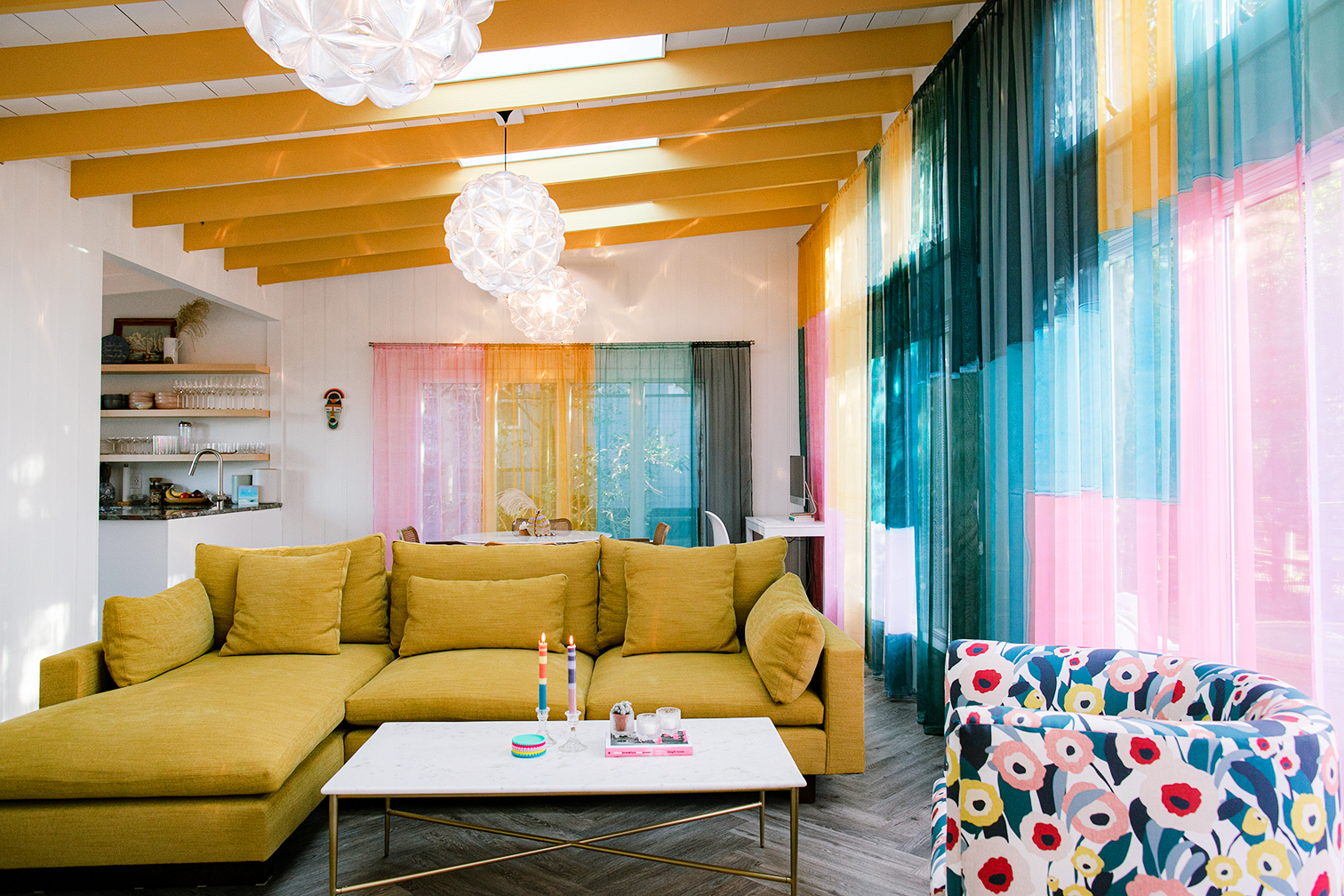 Living room with yellow sofa and rainbow curtains