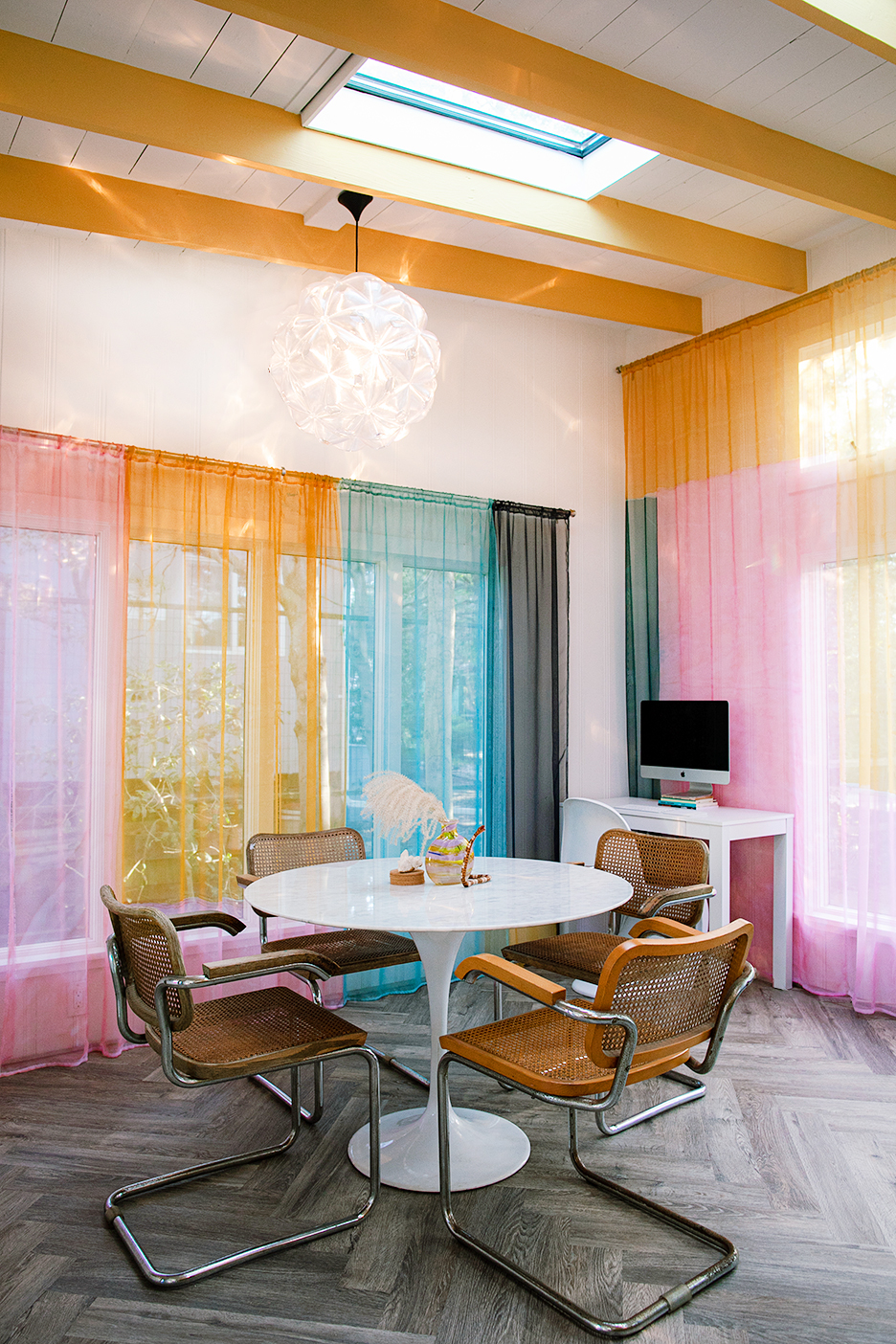 Dining room with tulip table and rainbow curtains