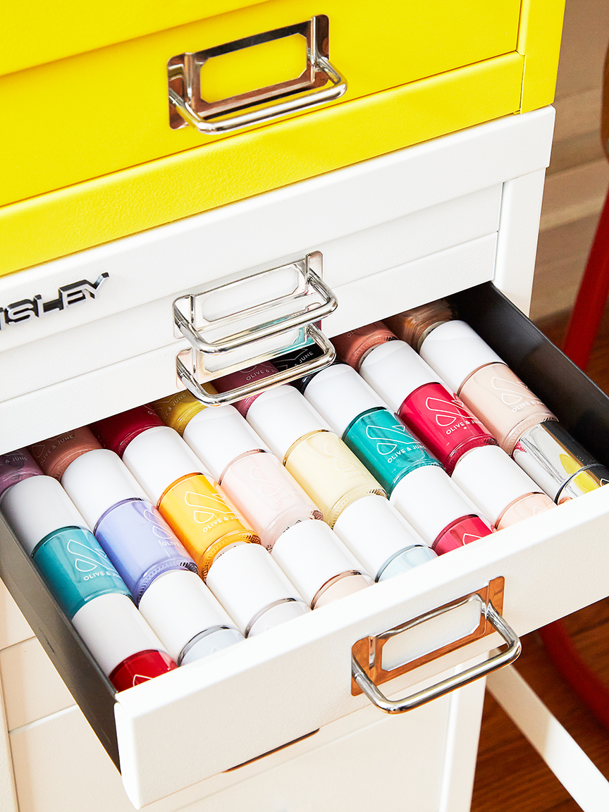 Cabinet drawer open showing nail polish stored inside