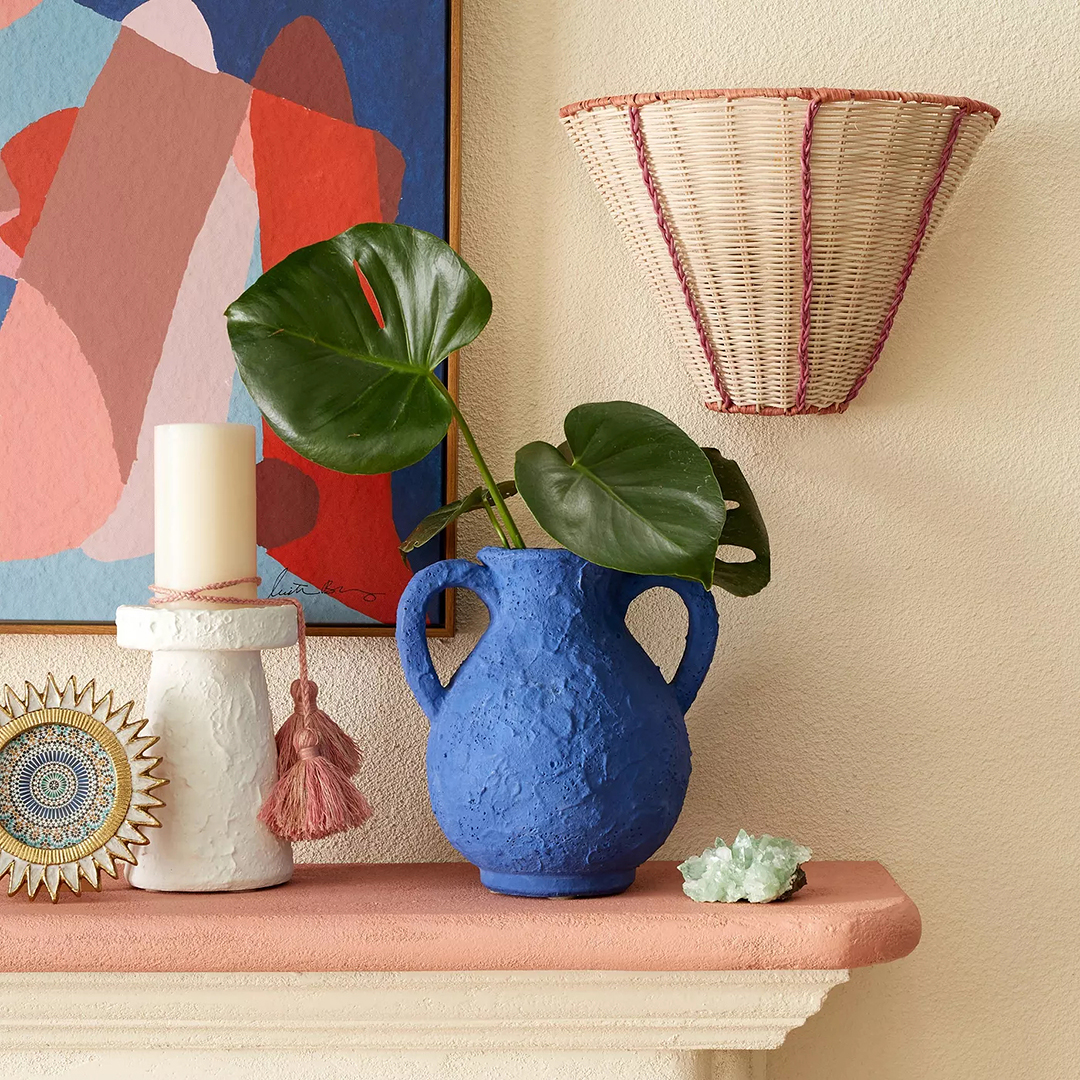 Woven rattan sconce next to a mantel