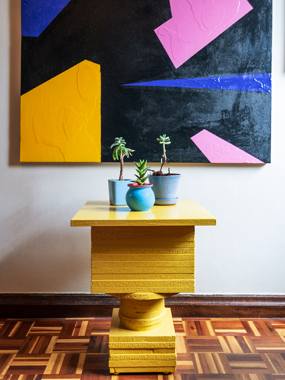 yellow side table below graphic artwork