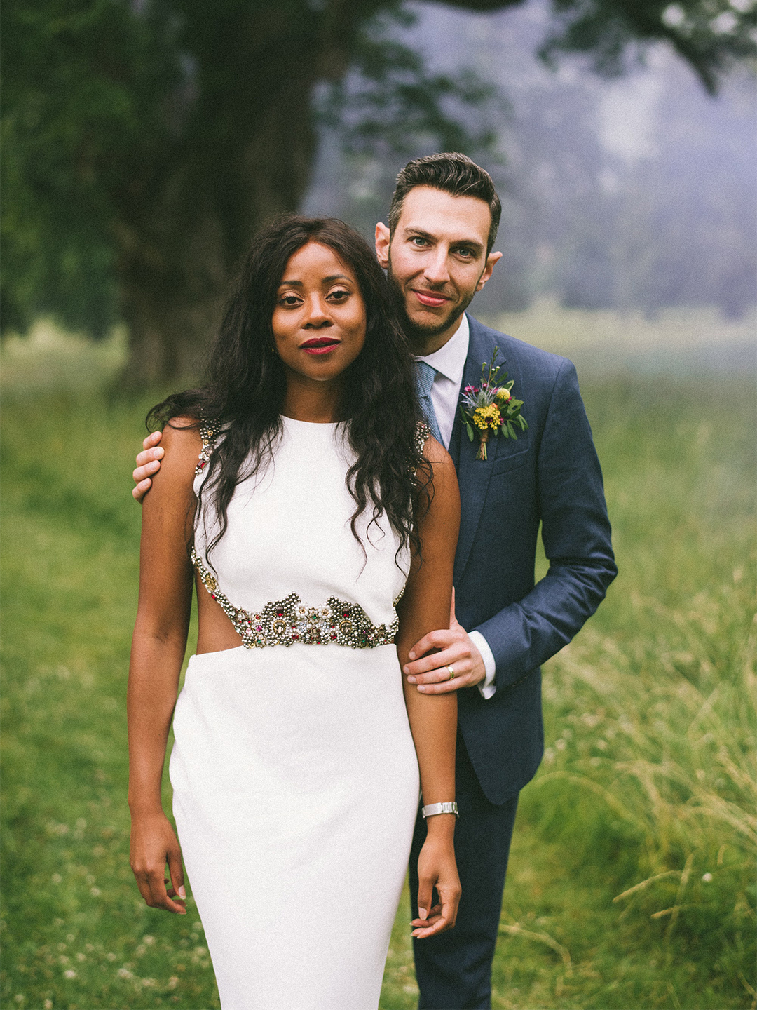 couple posing at their wedding in field