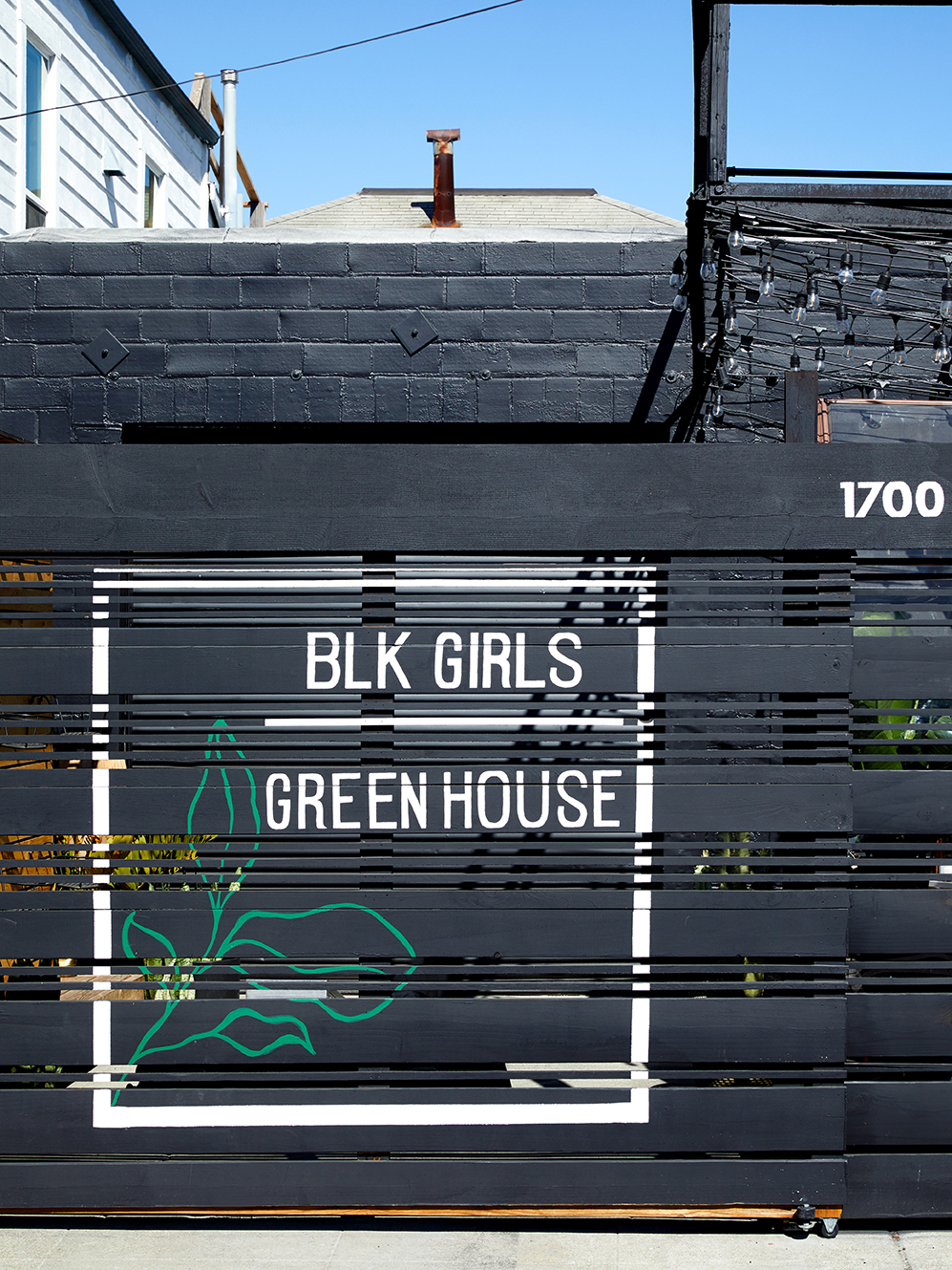 black fence with BLK Girls Greenhouse sign