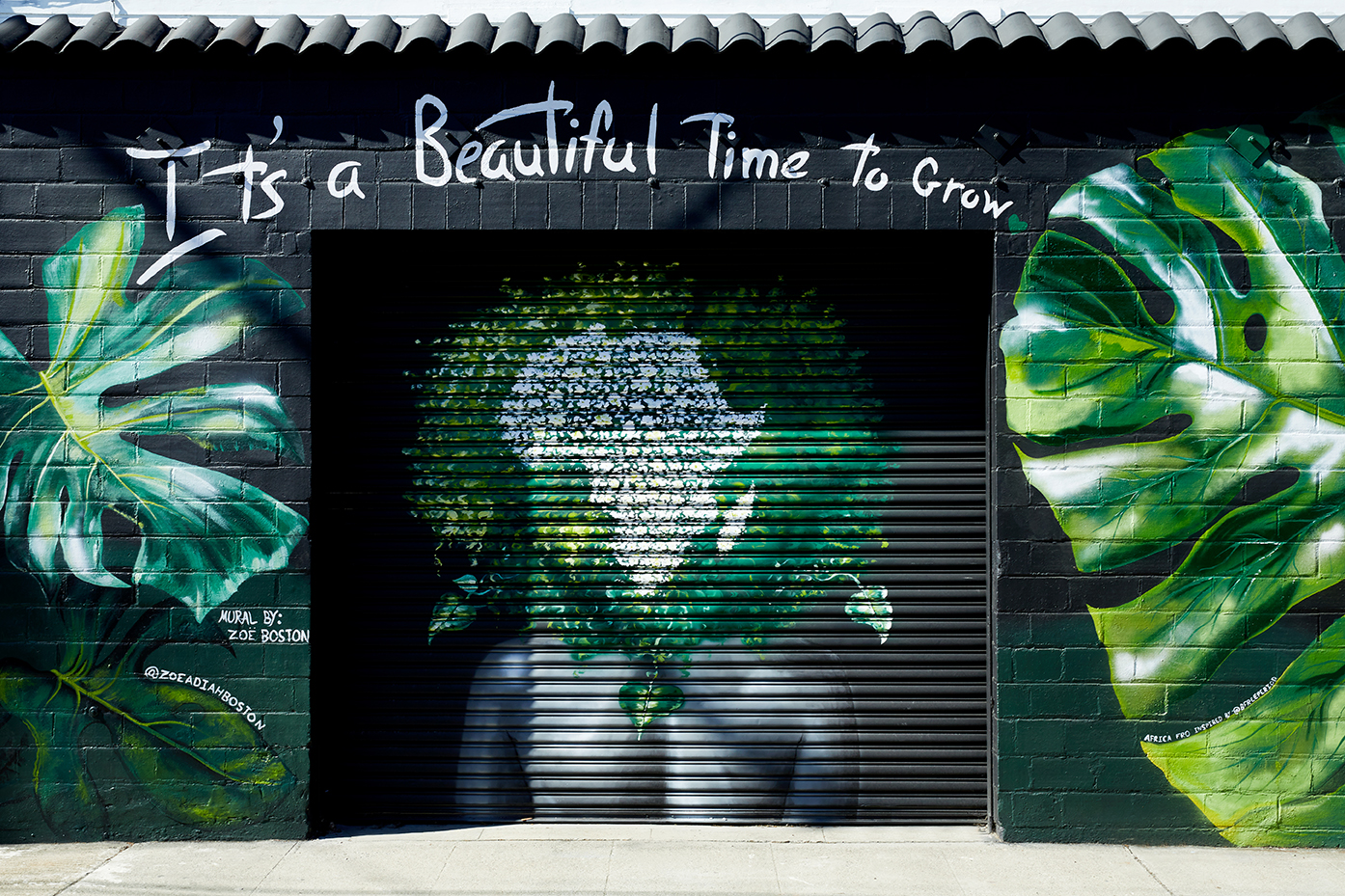 black garage with plant mural
