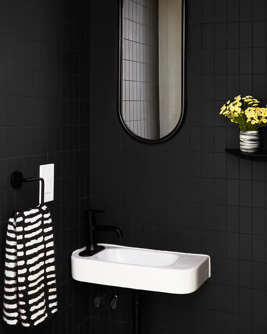 Black tiles, white sink and black mirror