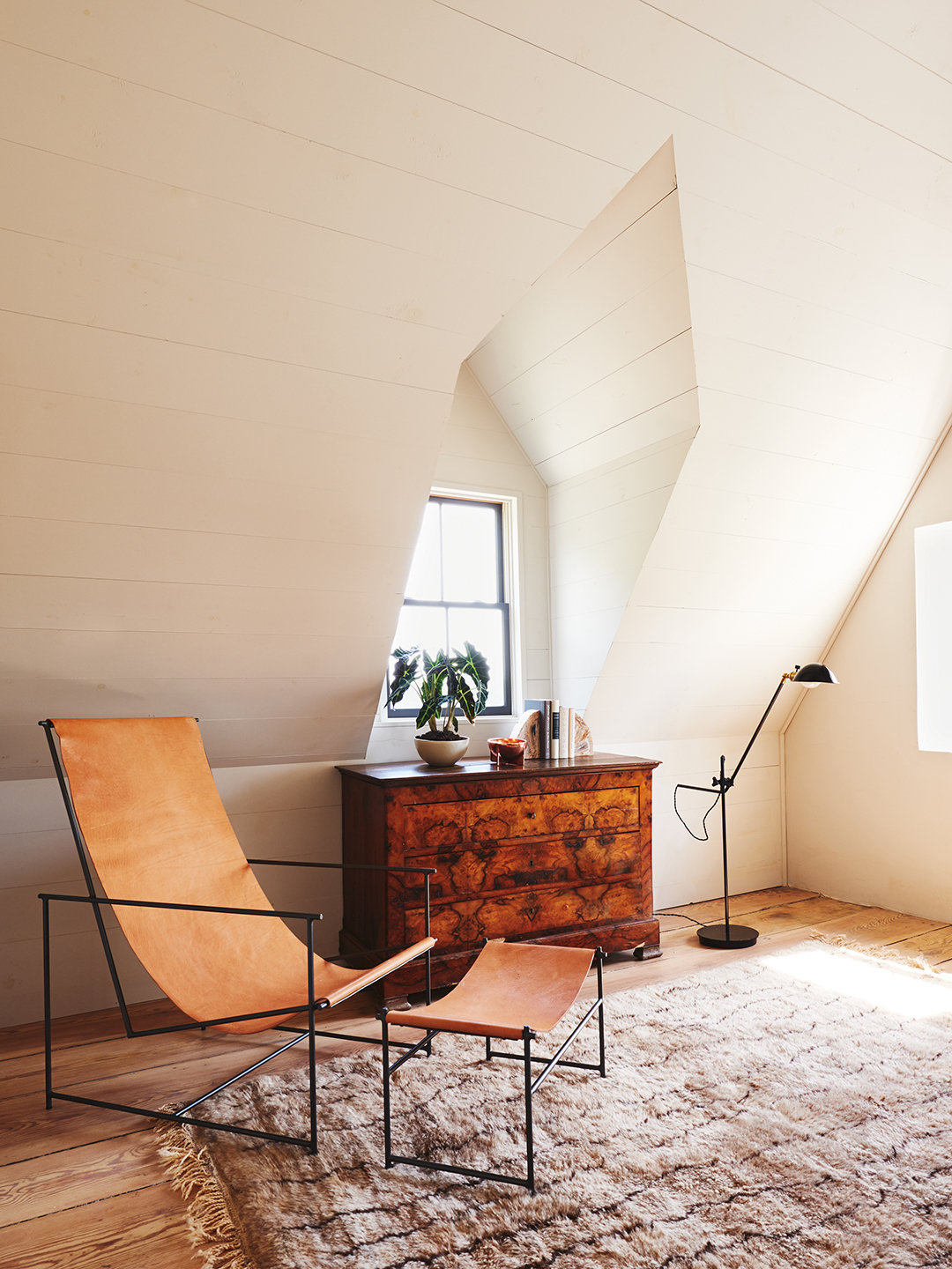 white paneled room with leather sling chair