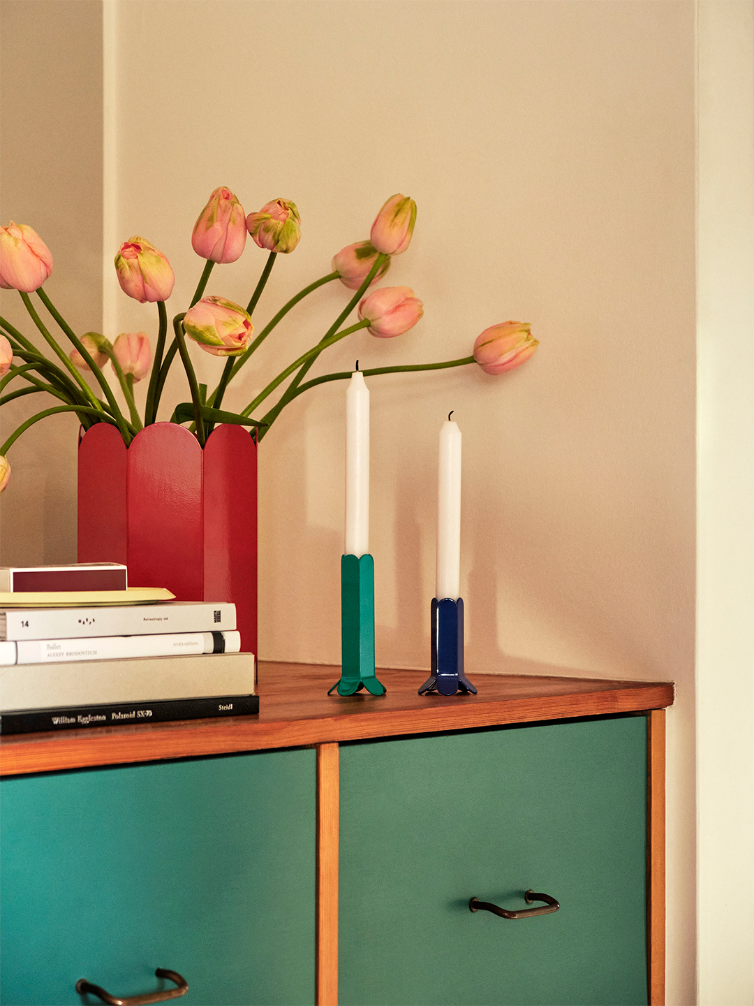 a vase with tulips and candlesticks