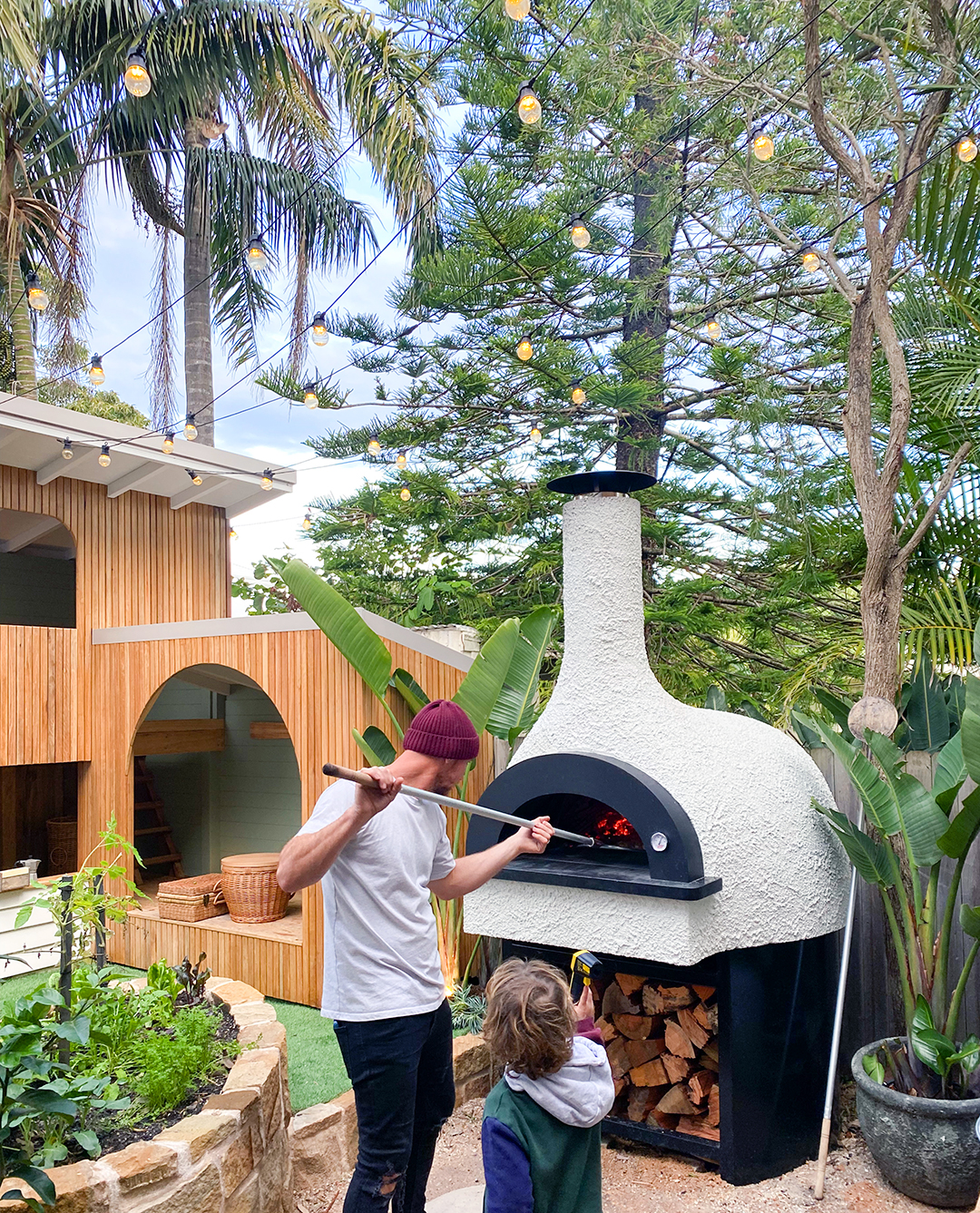 man taking pizza out of oven