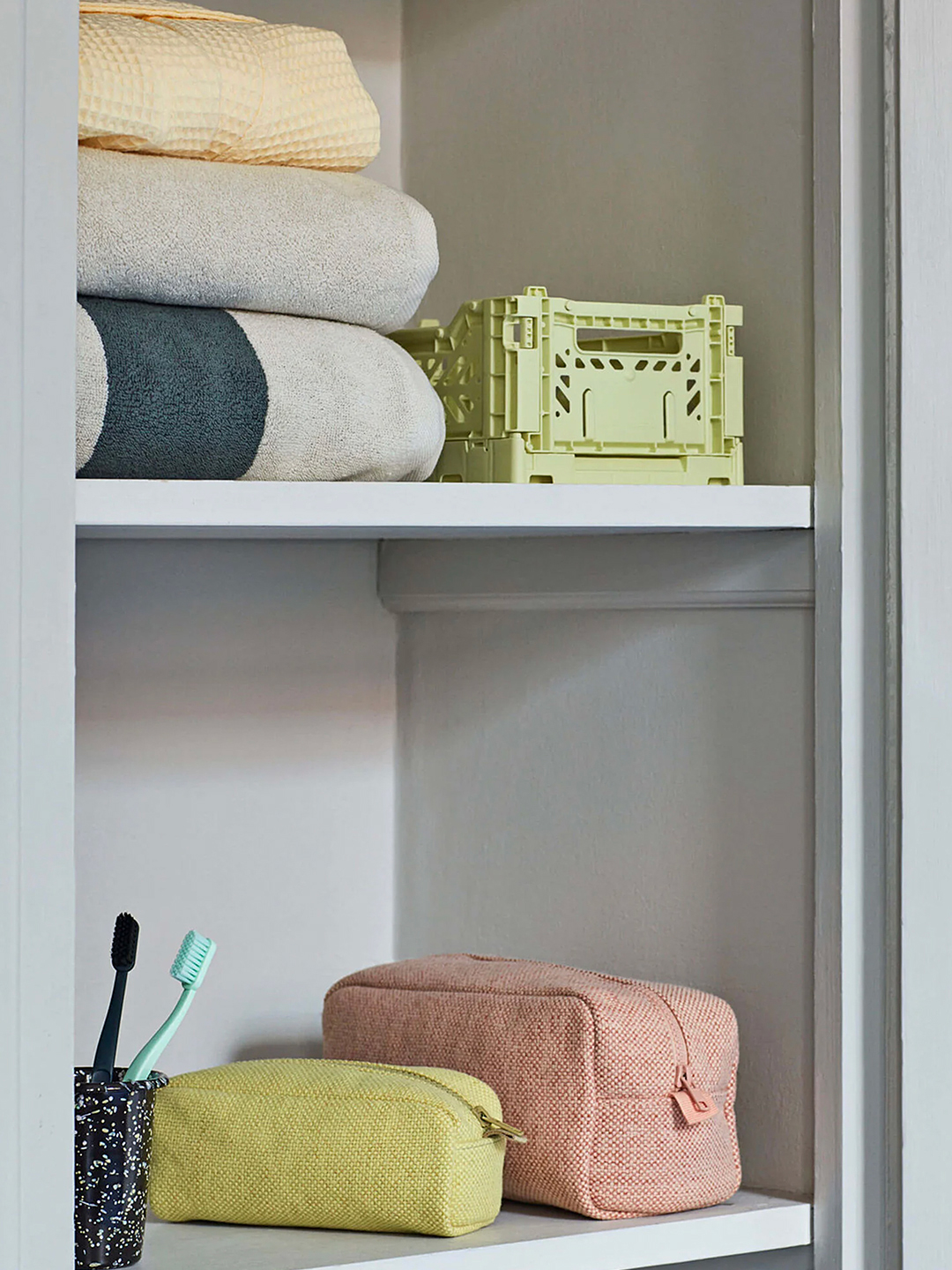 bathroom shelf with green crate storage