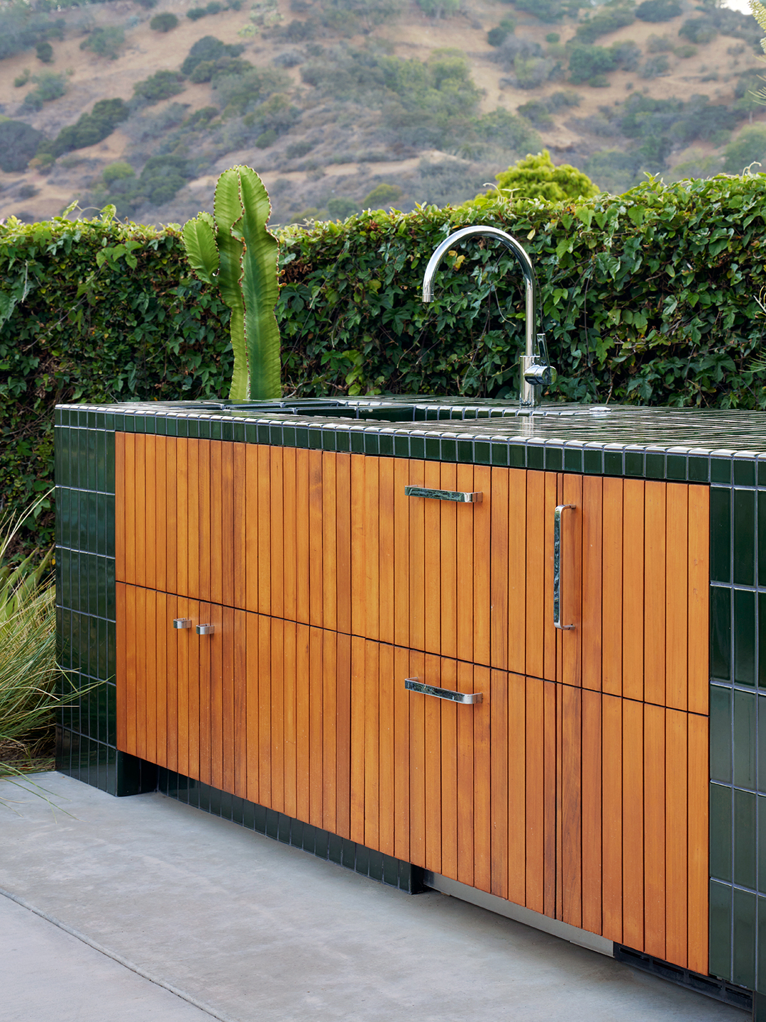 outdoor kitchen sink with wood drawers underneath