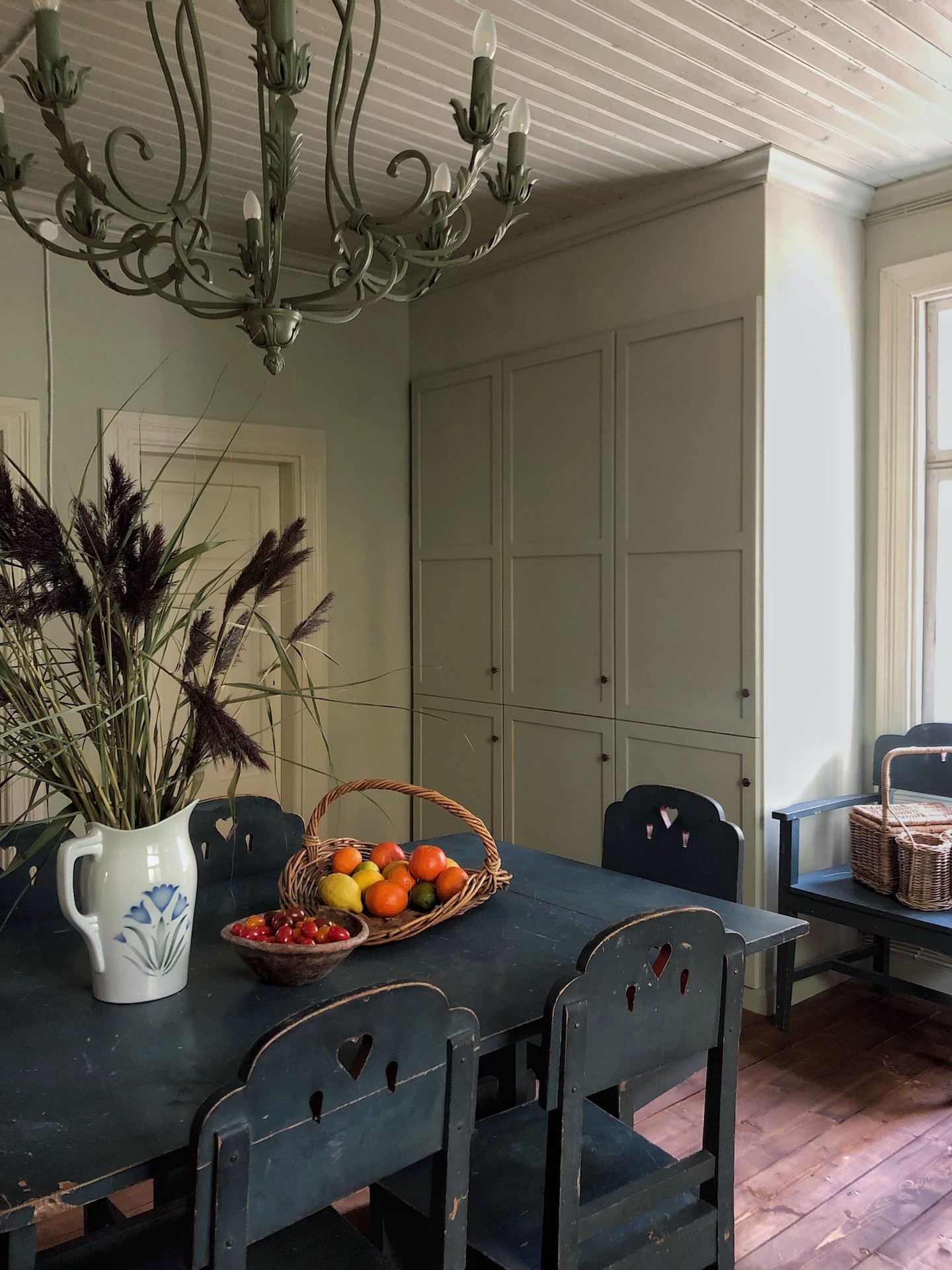 black dining table and green ikea cabinets