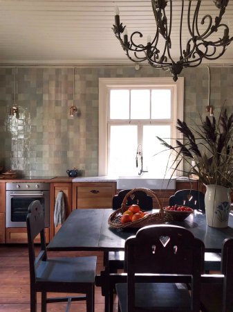 green tiled wall with black dining table