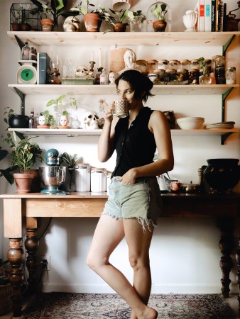 Brooke Darwin Drinking Coffee in Dark Kitchen