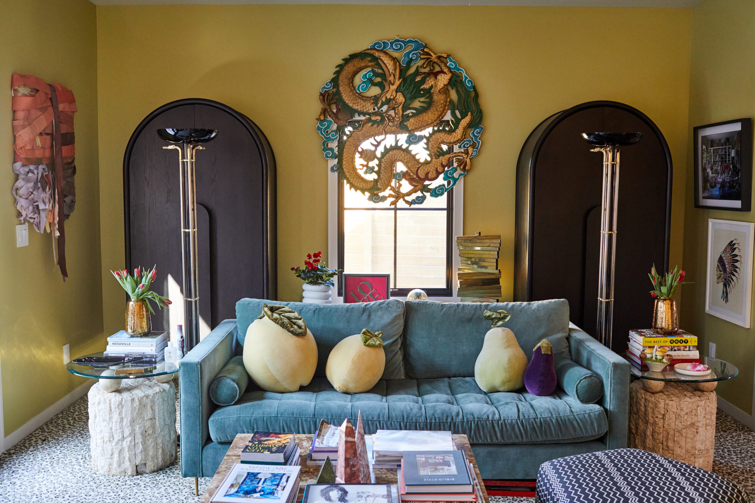 Blue coach with fruit-shaped pillows in a yellow room