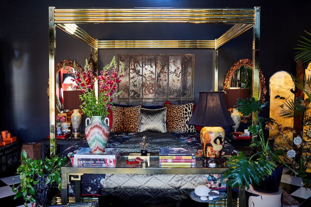 Maximalist black bedroom with gold bedframe