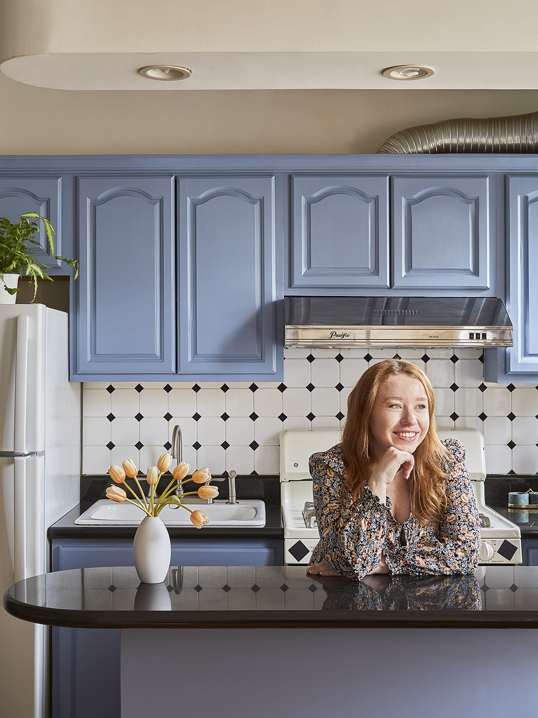 portrait of girl in a kitchen with blue cabinets