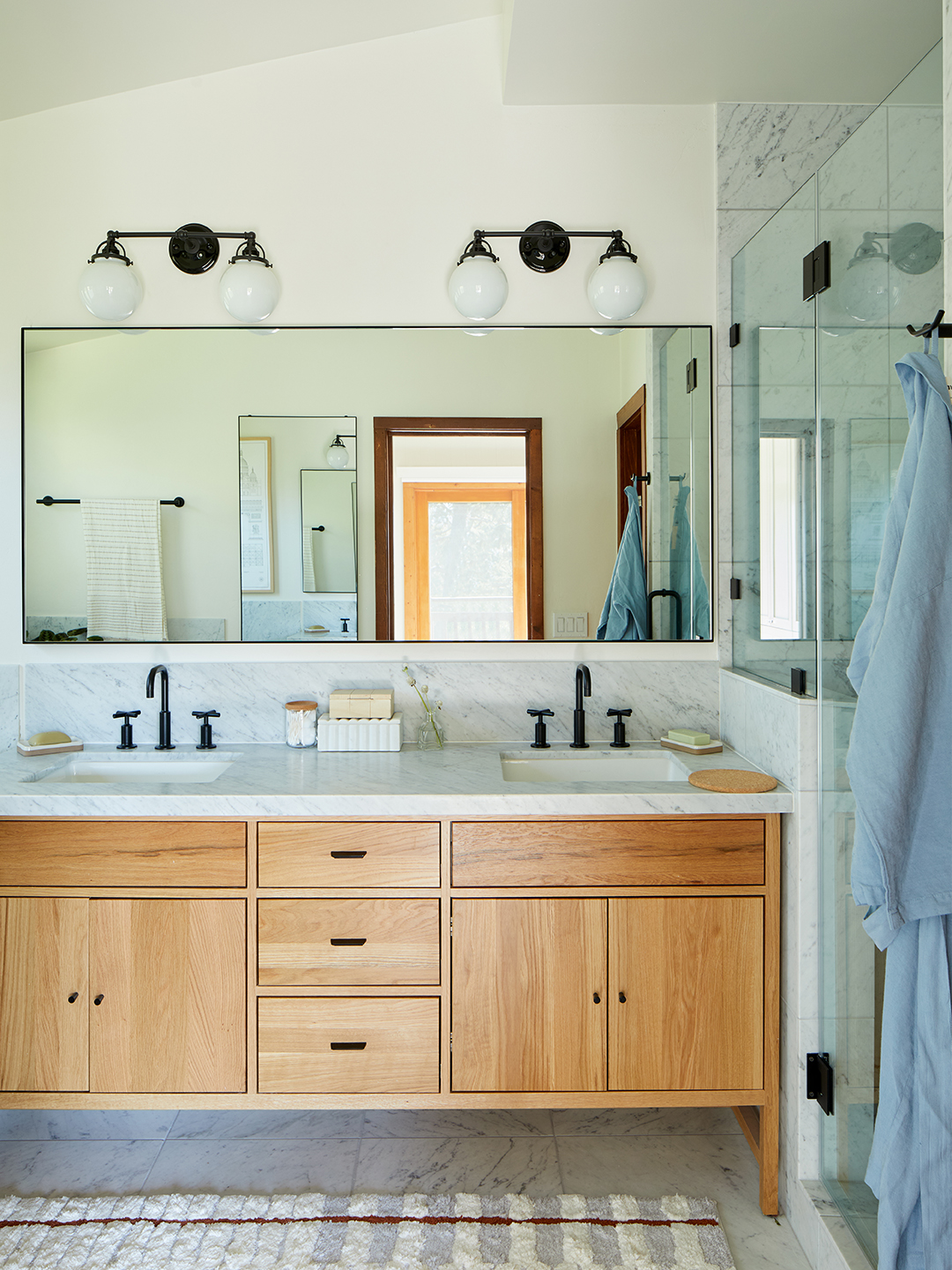 bathroom with wood vanity and marble counters.