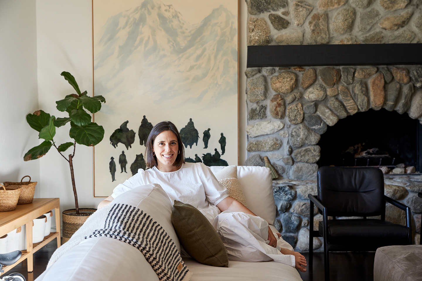 portrait of michelle toney sitting on a white sofa.