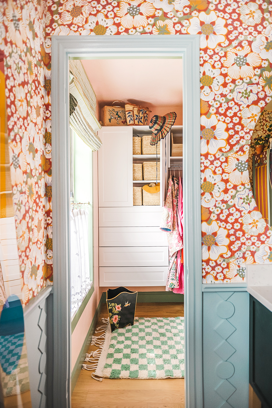 blue rectangular mirror, floral white and red wallpaper in a closet