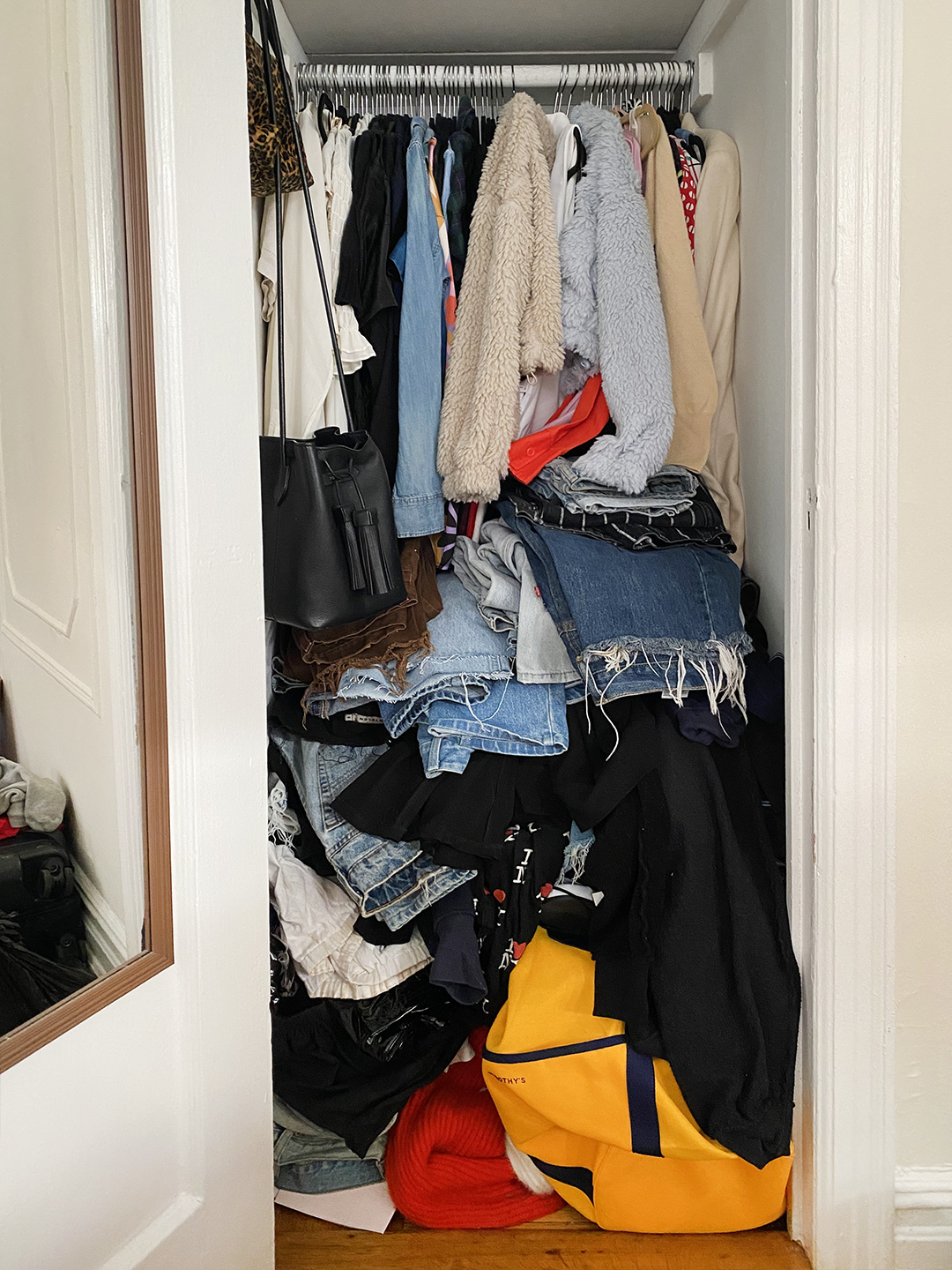 Messy closet with jeans piled up