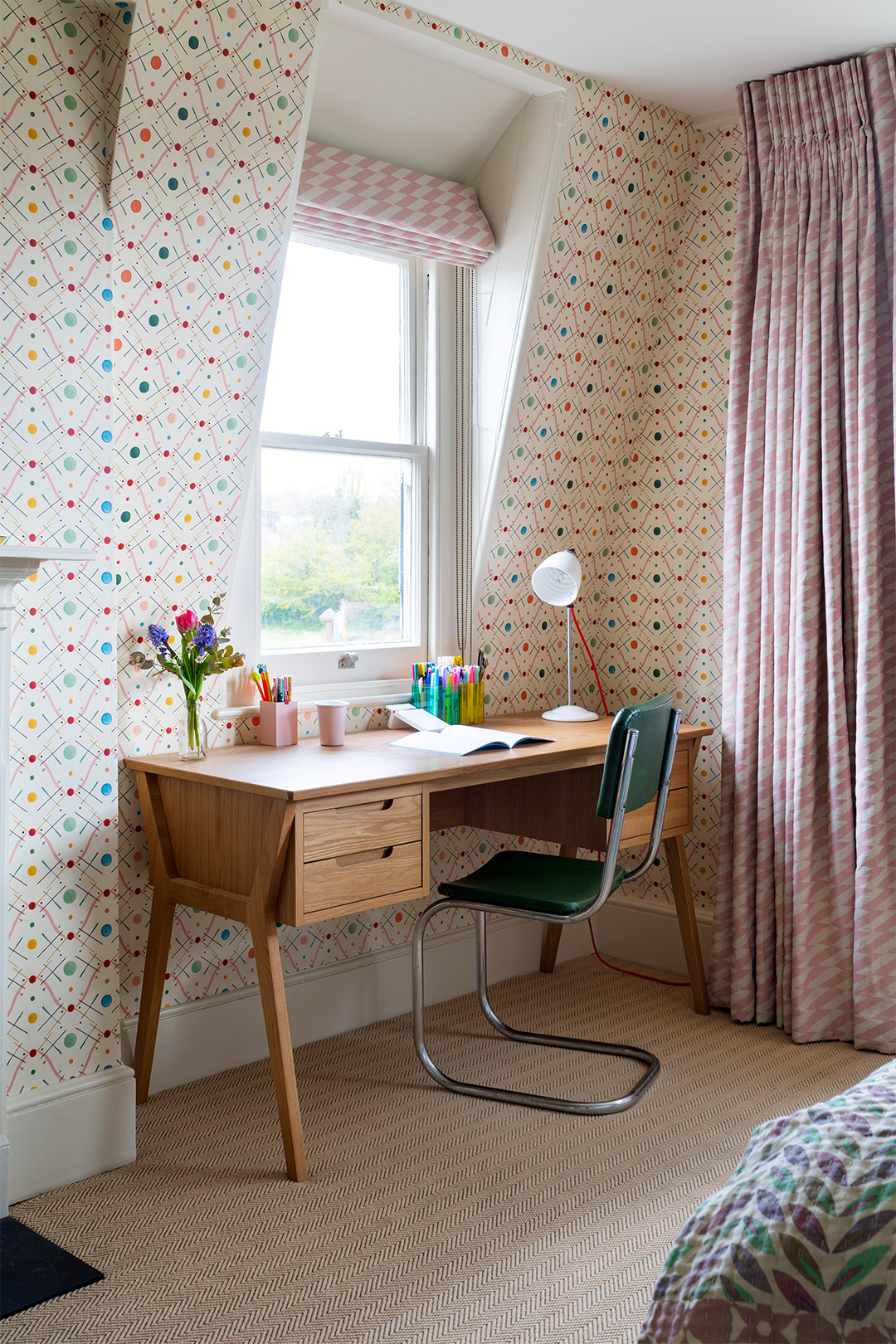 mid-century modern desk next to window paired with green, industrial chair