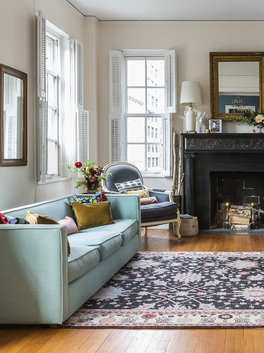 living room with hardwood floors and mint green sofa