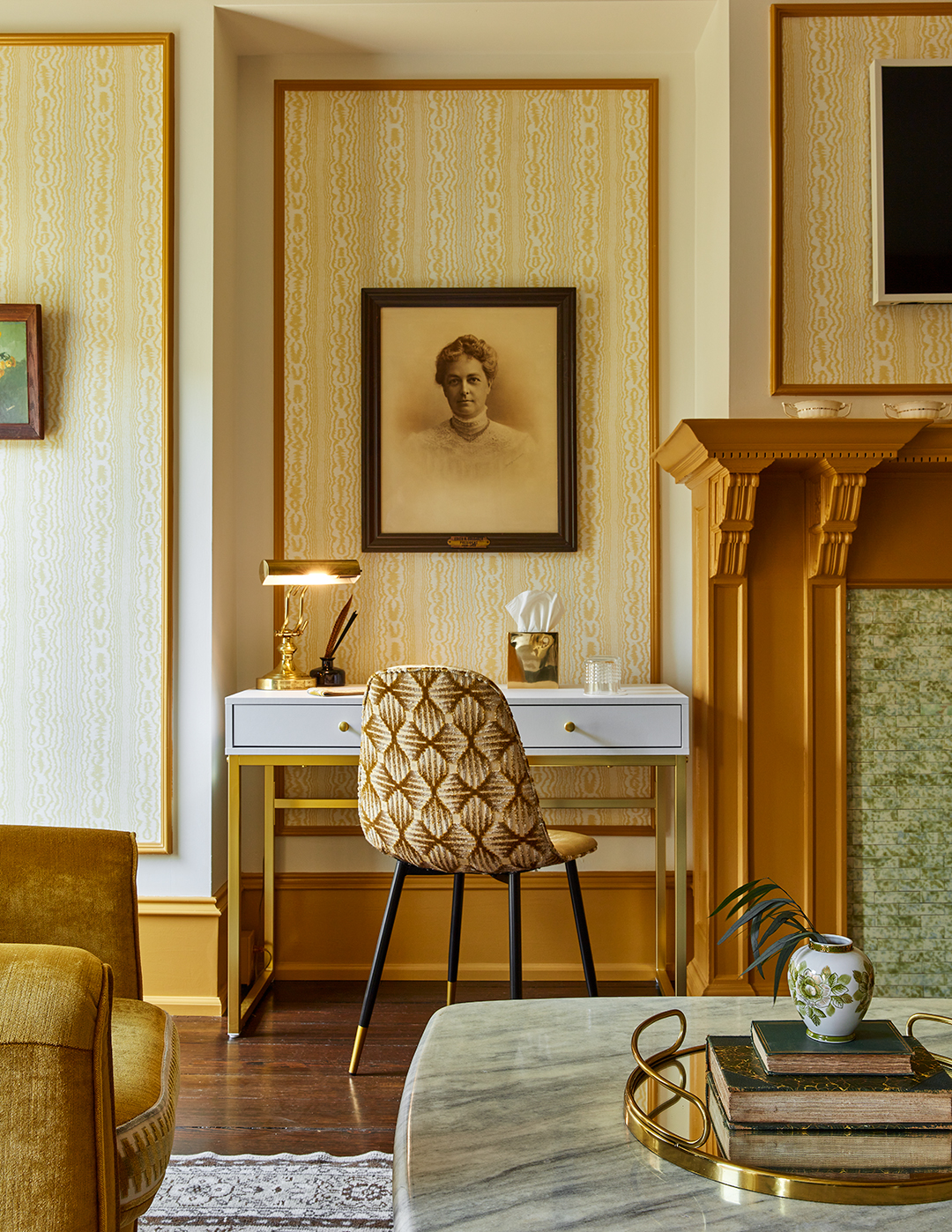 Yellow painted fireplace and white desk