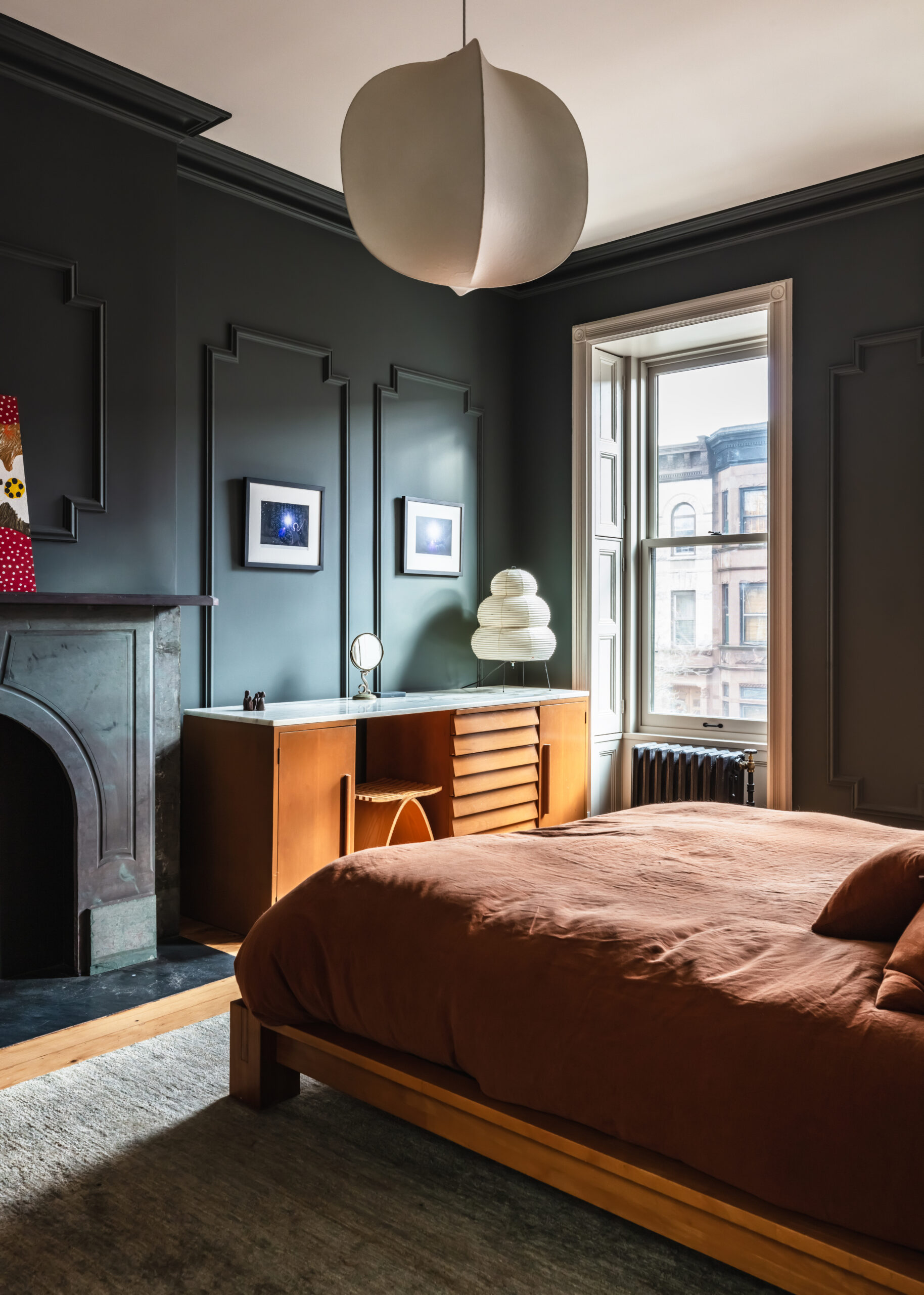 Green painted walls in paneled bedroom with wooden platform bed