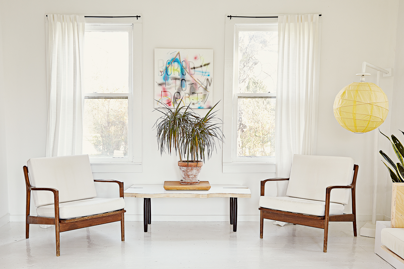 white living room with armchairs white curtains