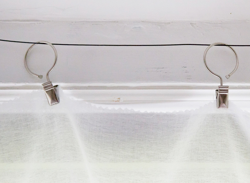 metal clips attached to wire and sheer cotton fabric