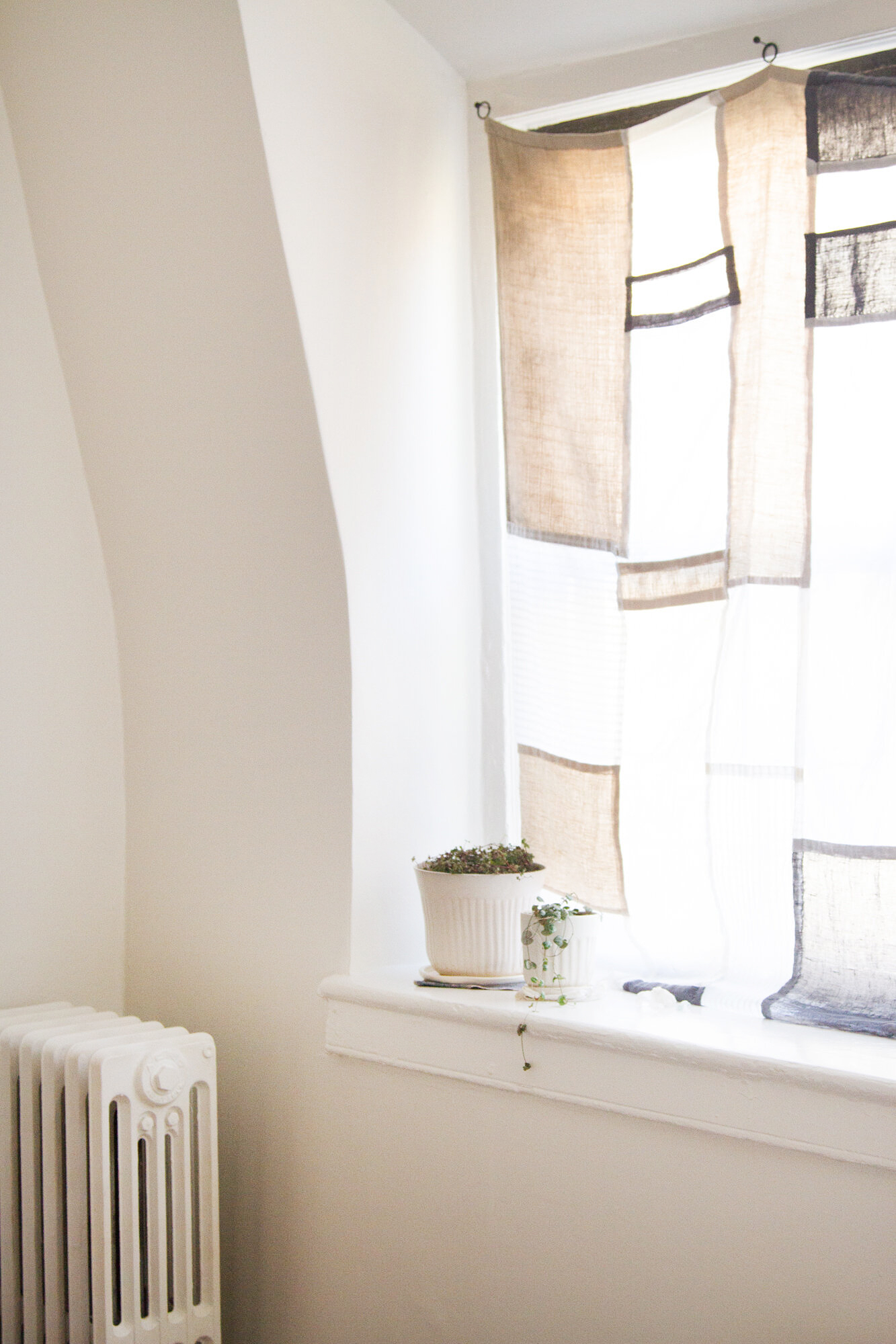 patchwork curtain hanging from oversized tacks