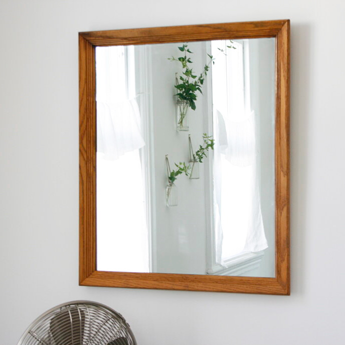 cafe curtains and hanging plant shown in mirror reflection