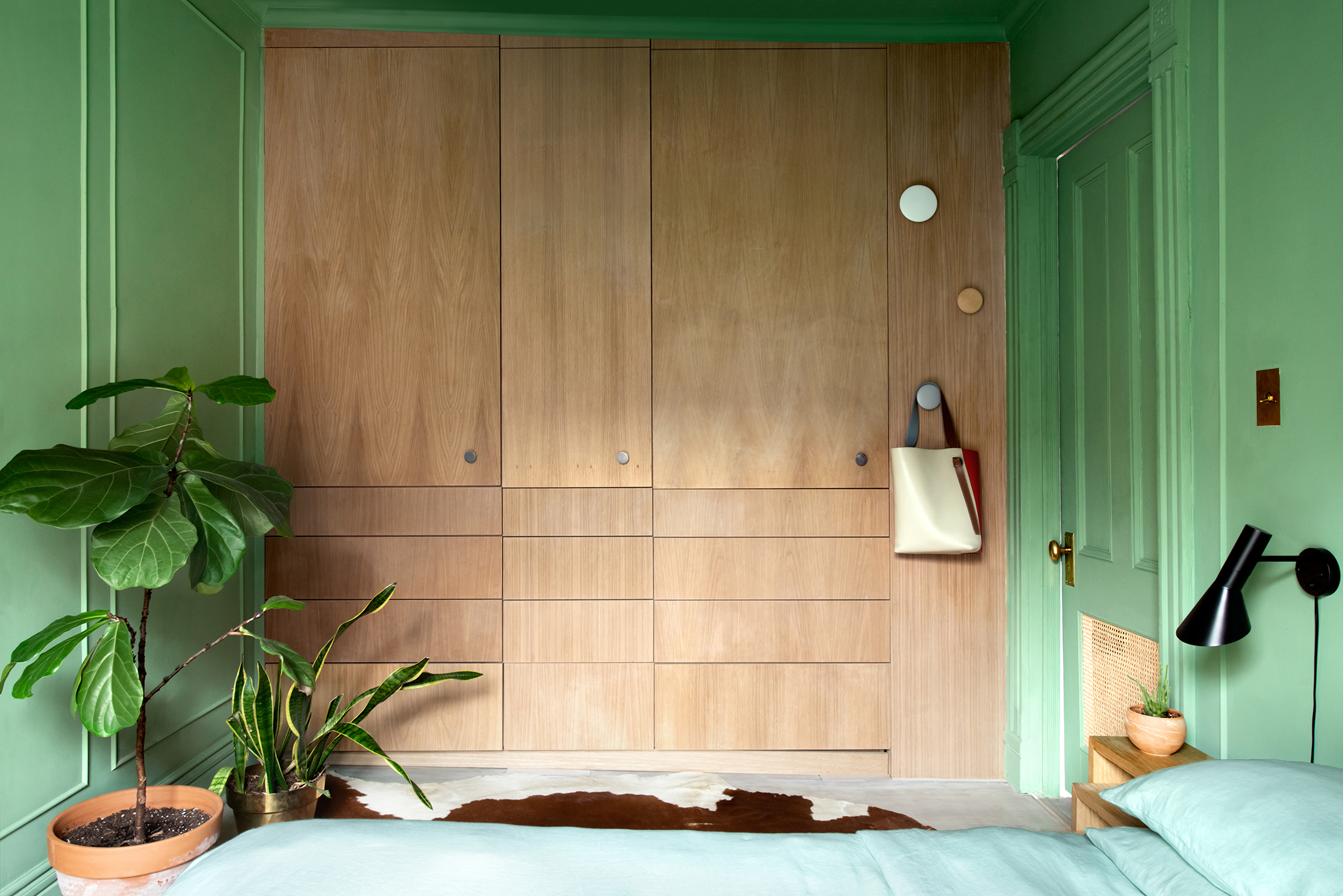 fiddle leaf fig and snake plant in green bedroom