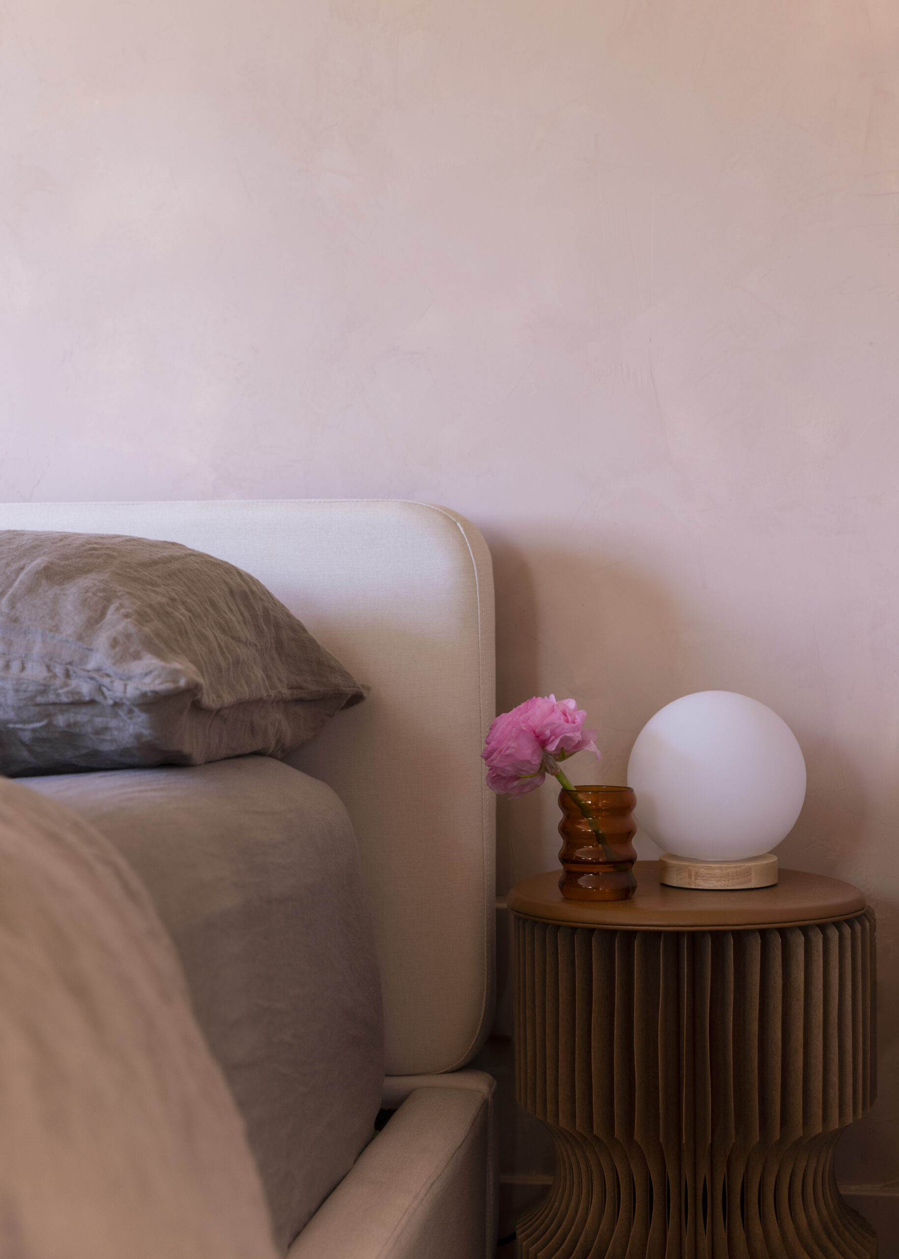 Bed in front of light pink wall