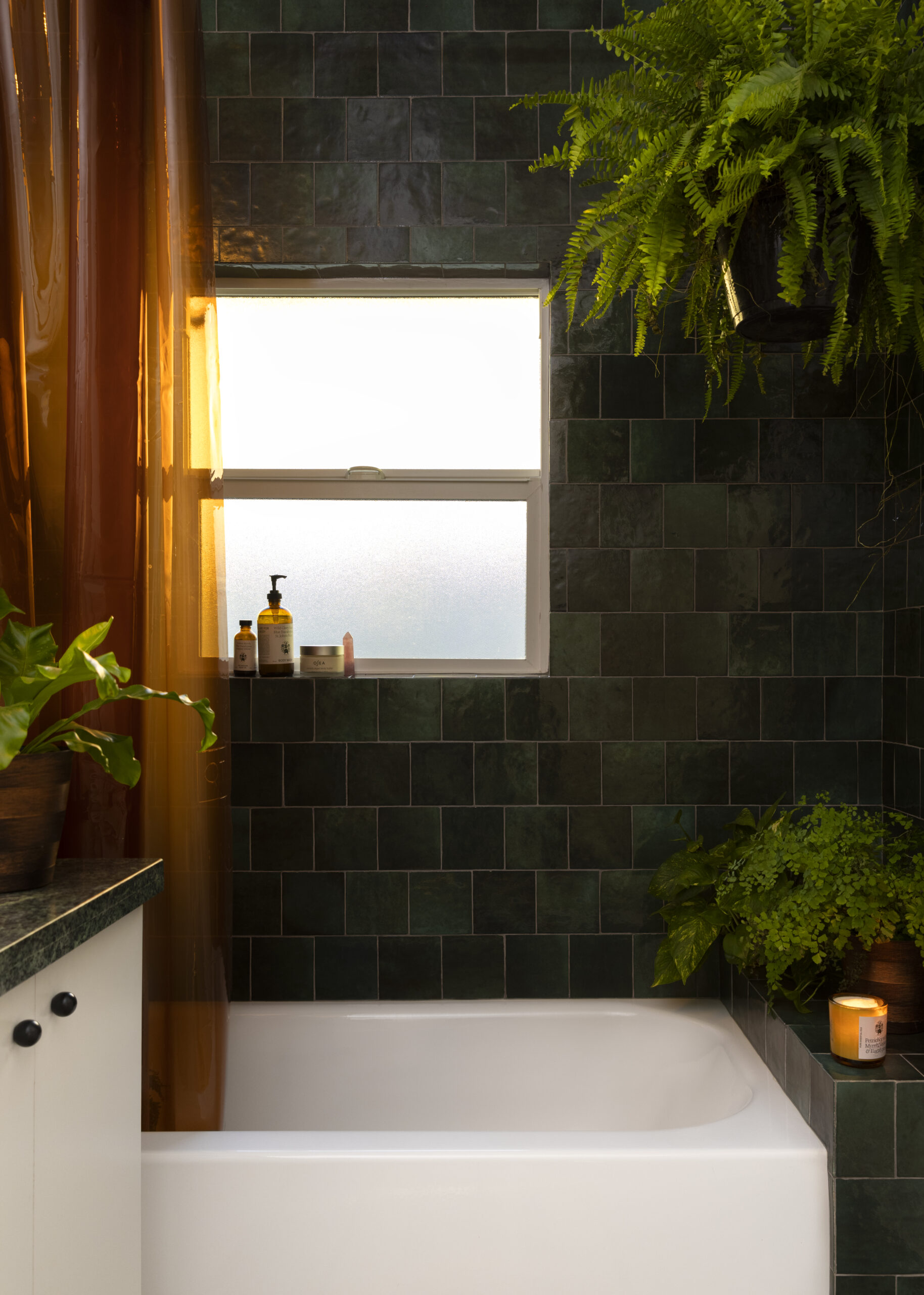 Bathroom with green tile and white tub