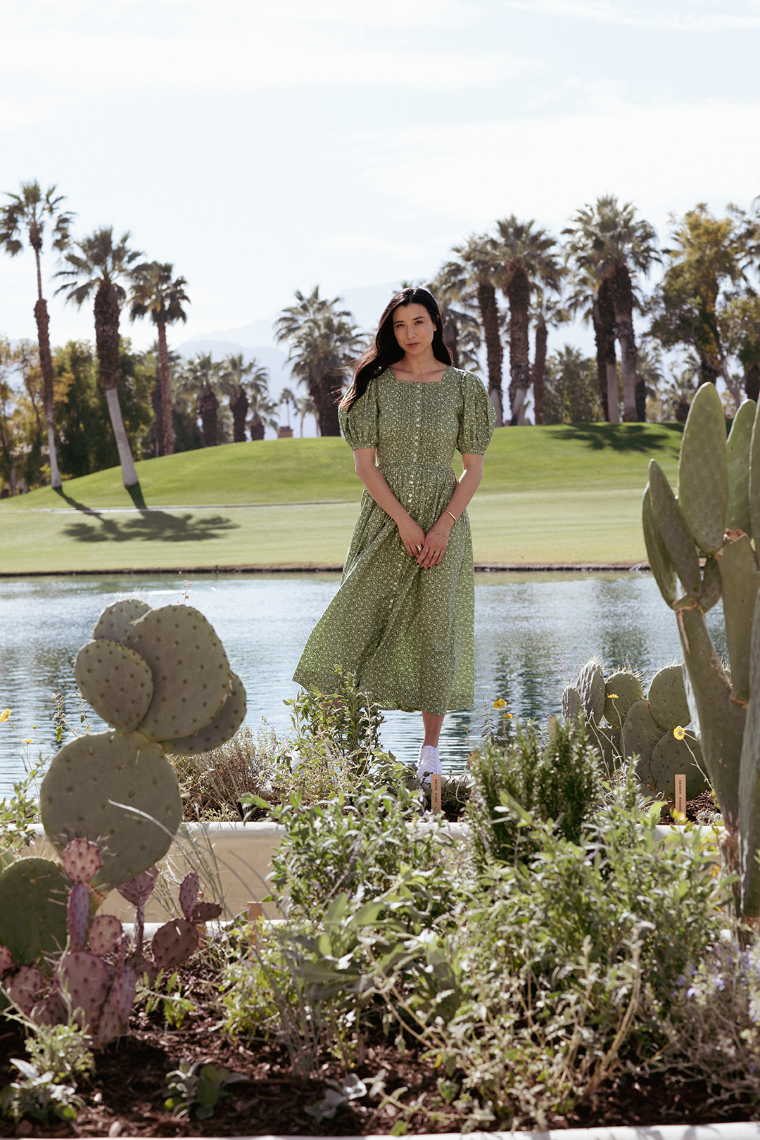 Lily Kwong in green dress standing with her planters