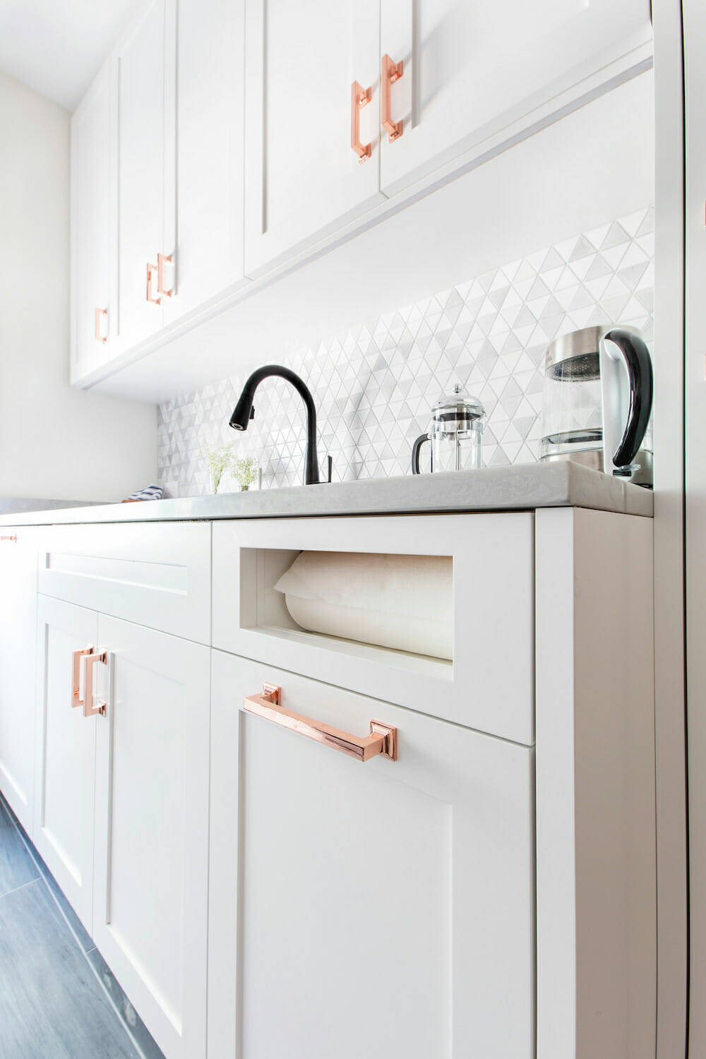 white kitchen cabinets with inset paper towel roll