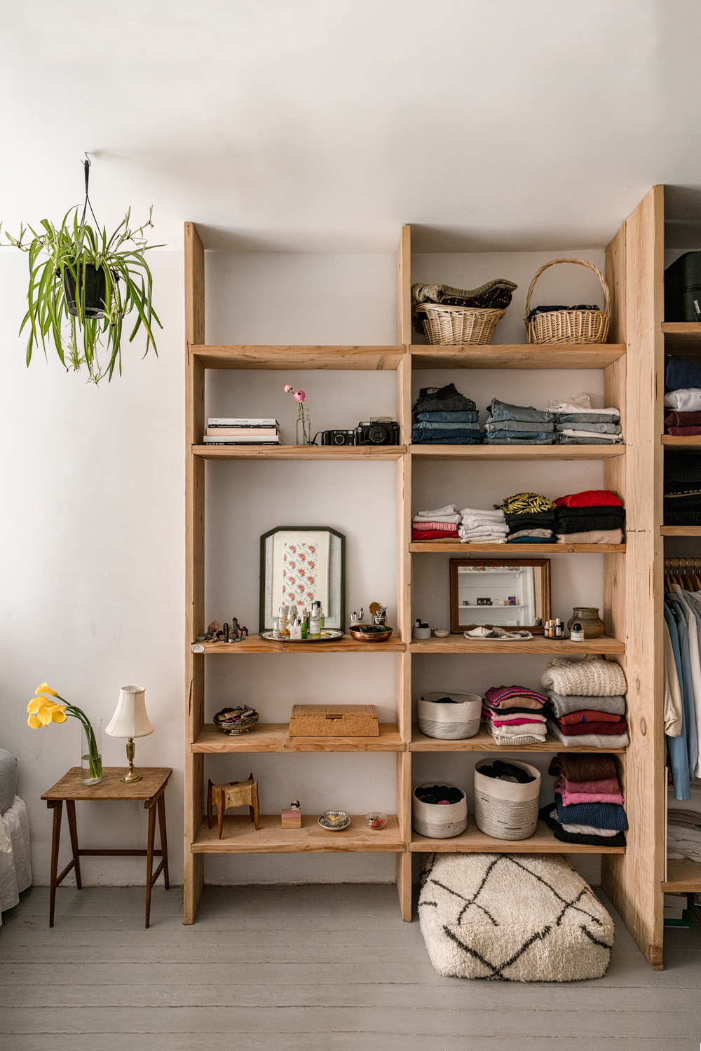 wooden bookcases with clothes on them