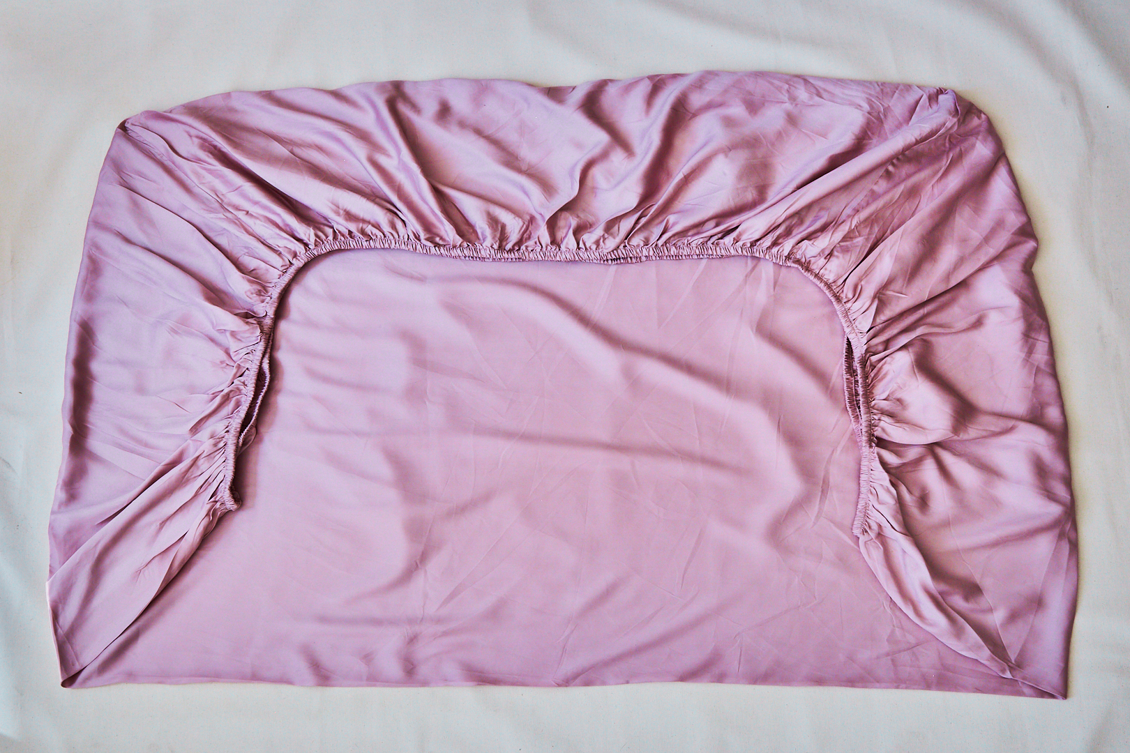 pink fitted sheet folded in half