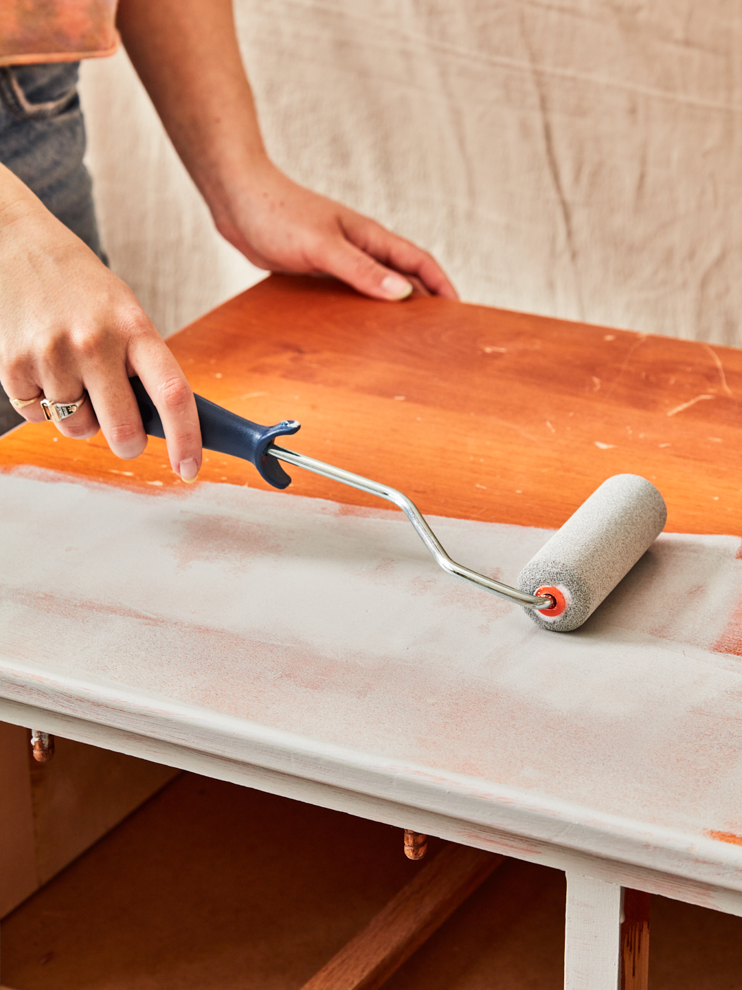 adding primer to wooden dresser with roller