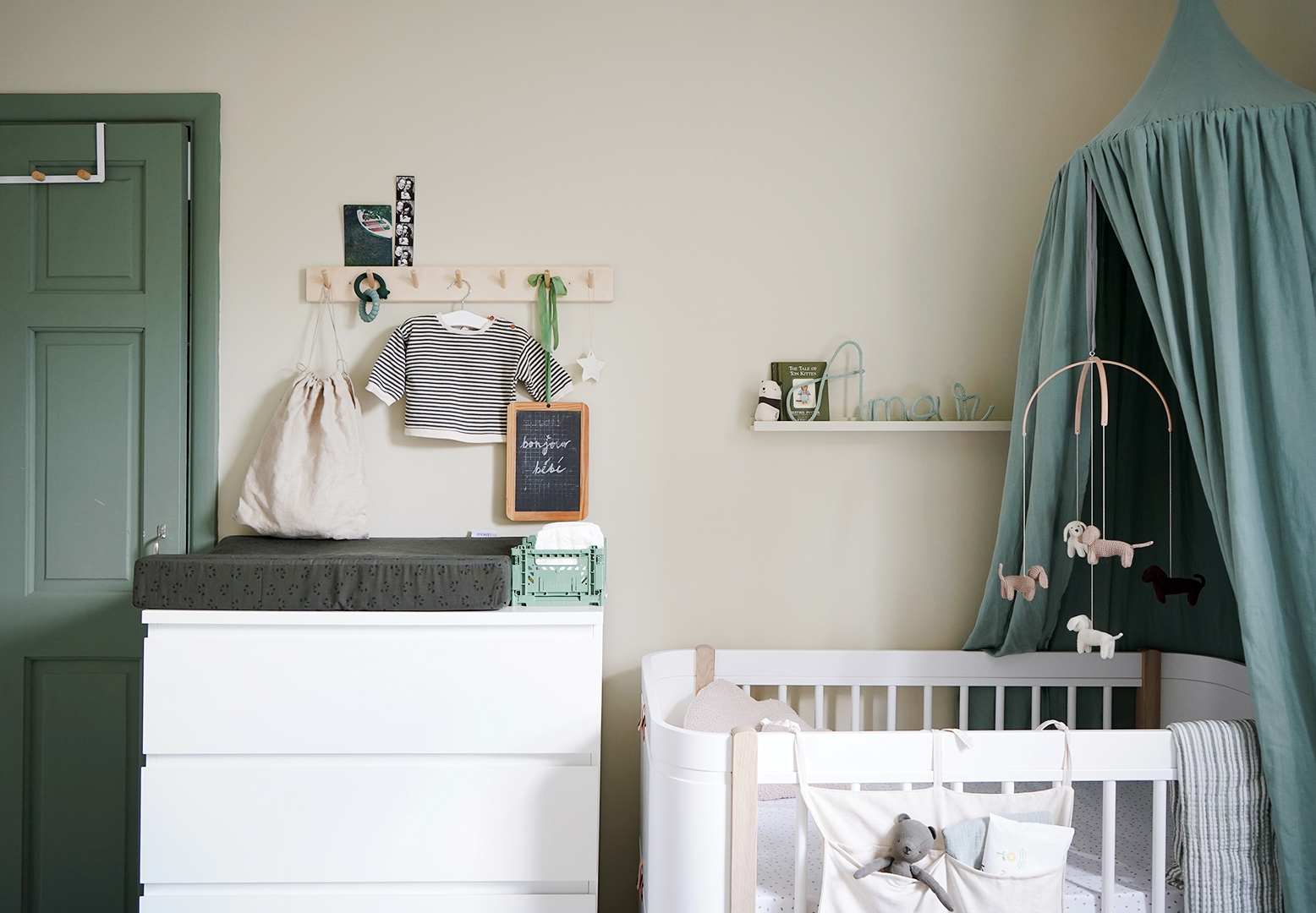 modern white crib and changing table with green accents