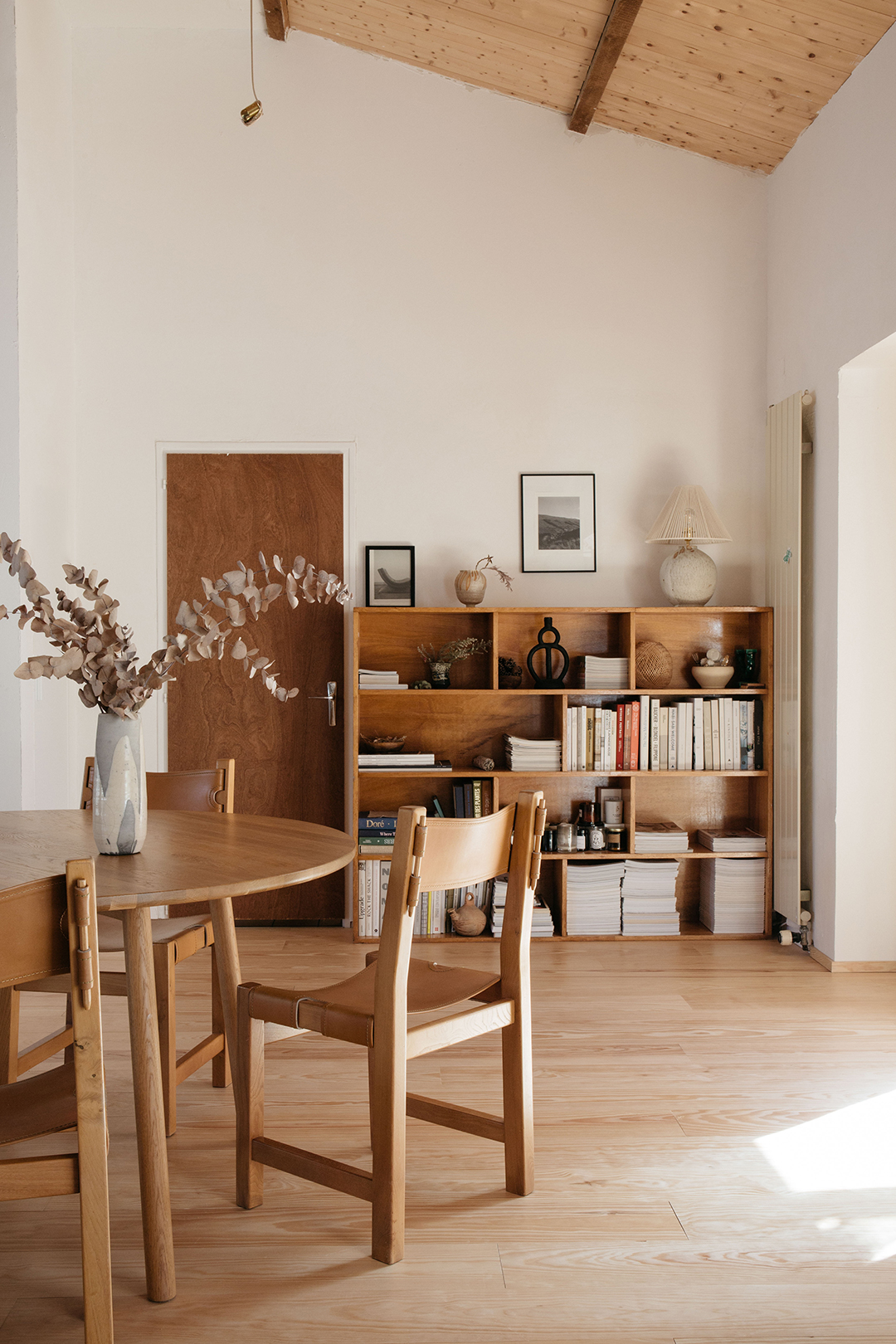 Round wood table and chairs with bookcase in background