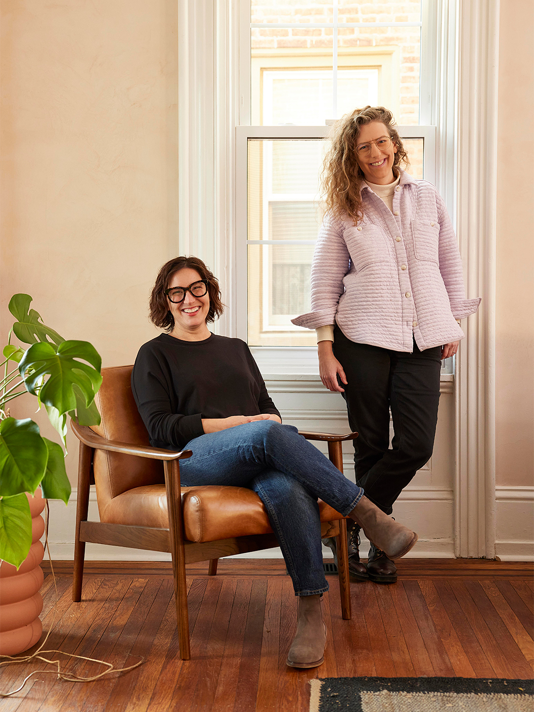 women sitting in chair and standing