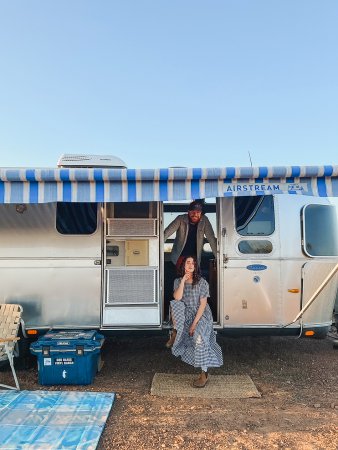 couple standing in the doorway of an airstream