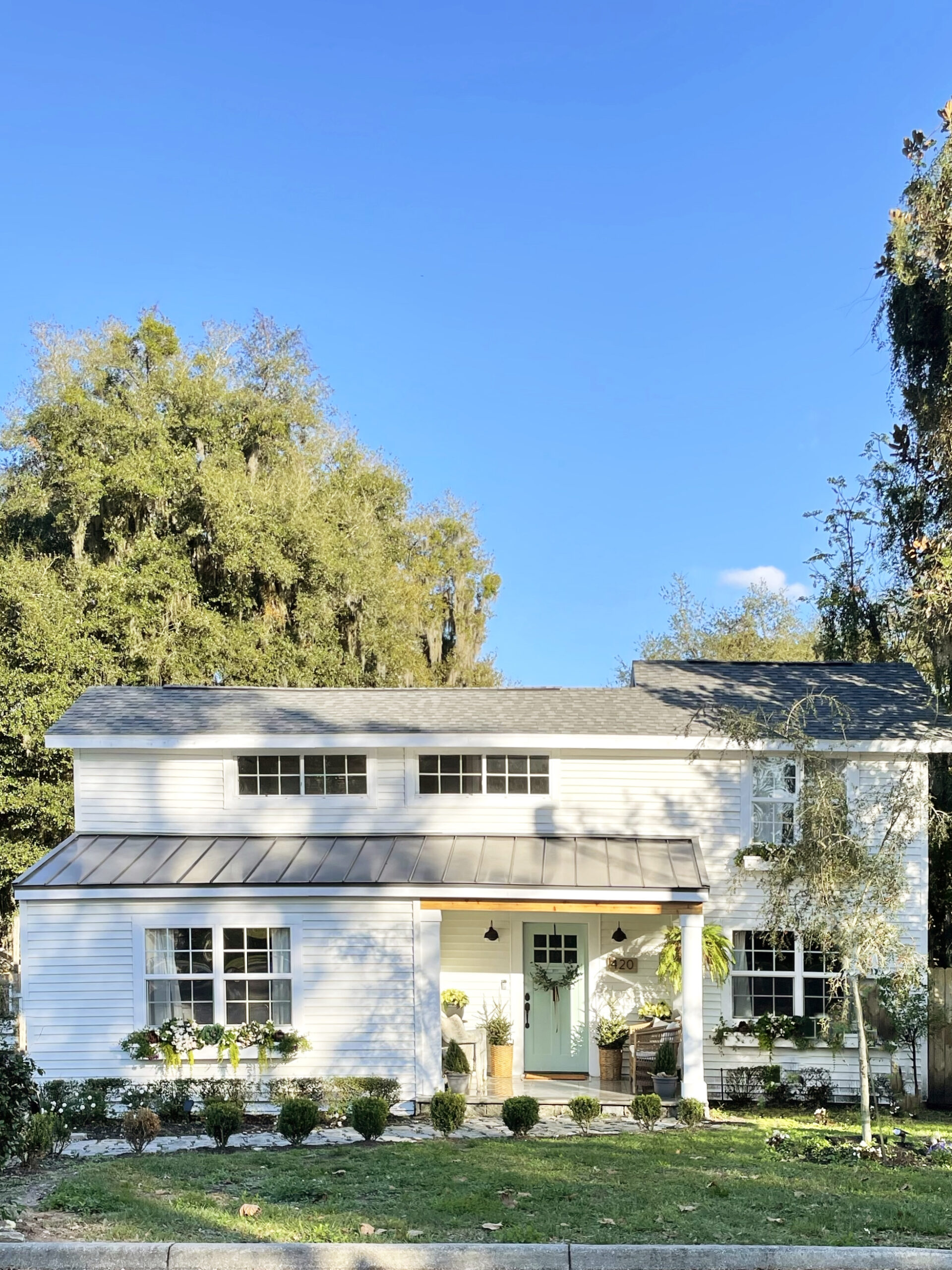 white house with lush yard