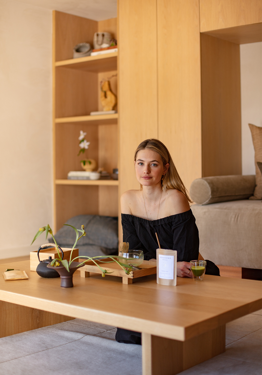 blonde woman sitting at low dining table