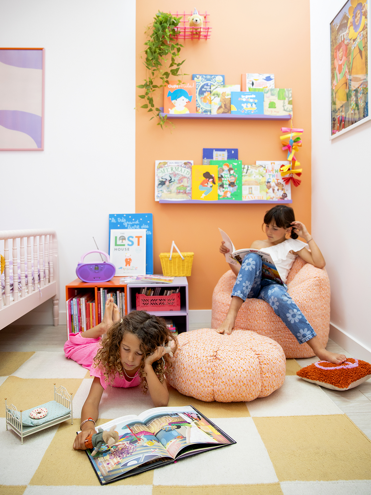 kids’ reading nook with salmon-colored wall stripe and lavender shelves