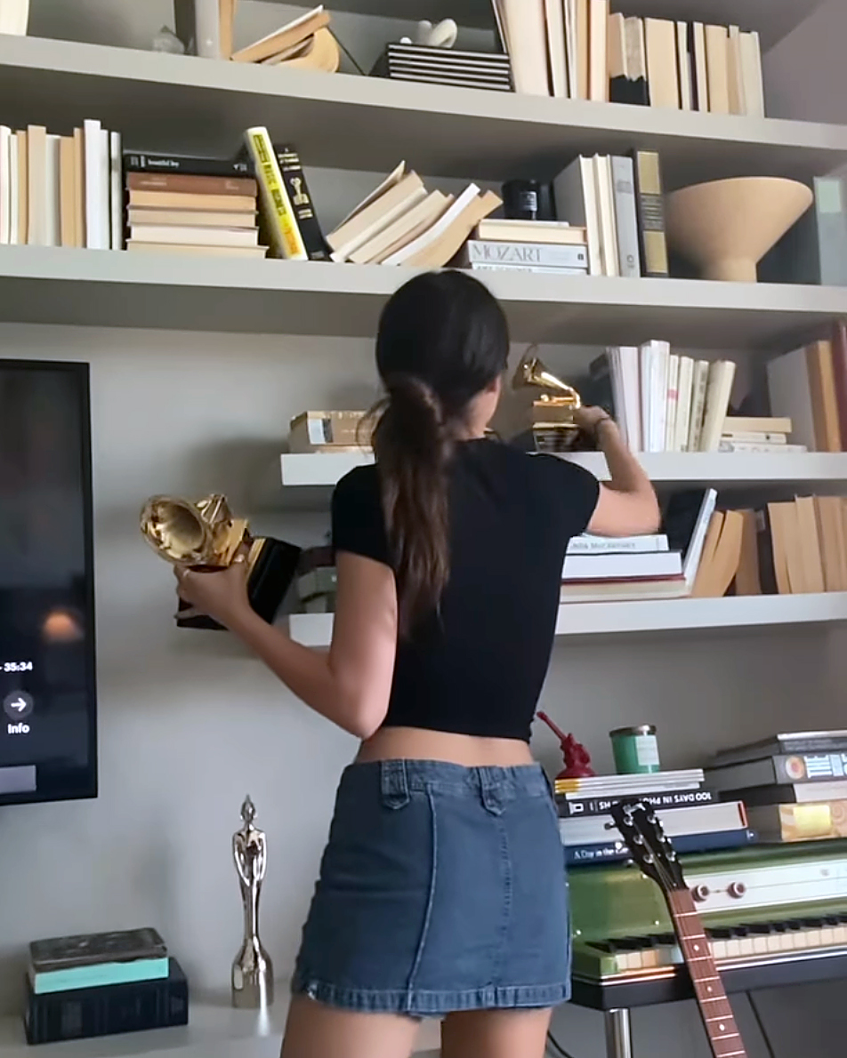 woman putting things on bookshelf