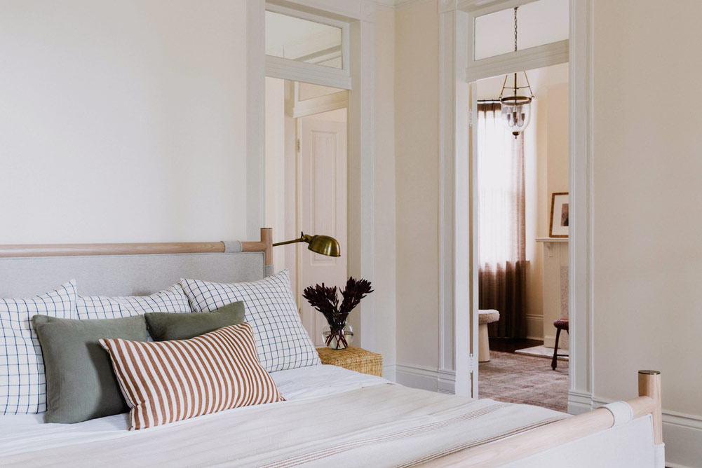 bedroom with striped pillow and rattan side table