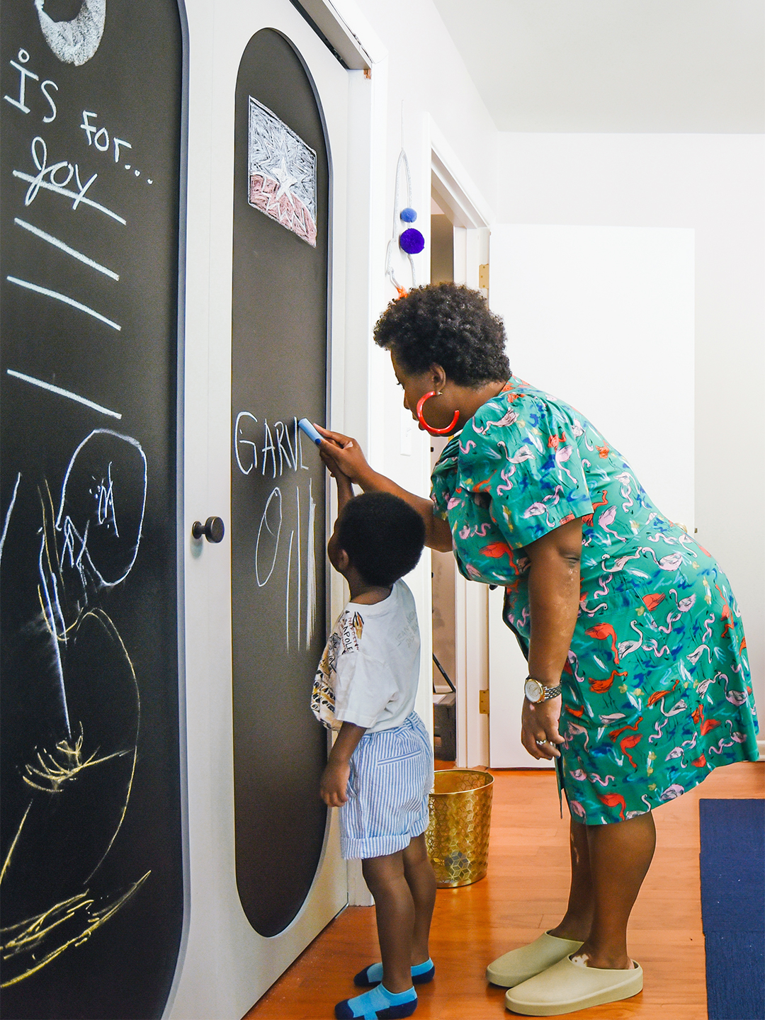 mom and son drawing on chalk board